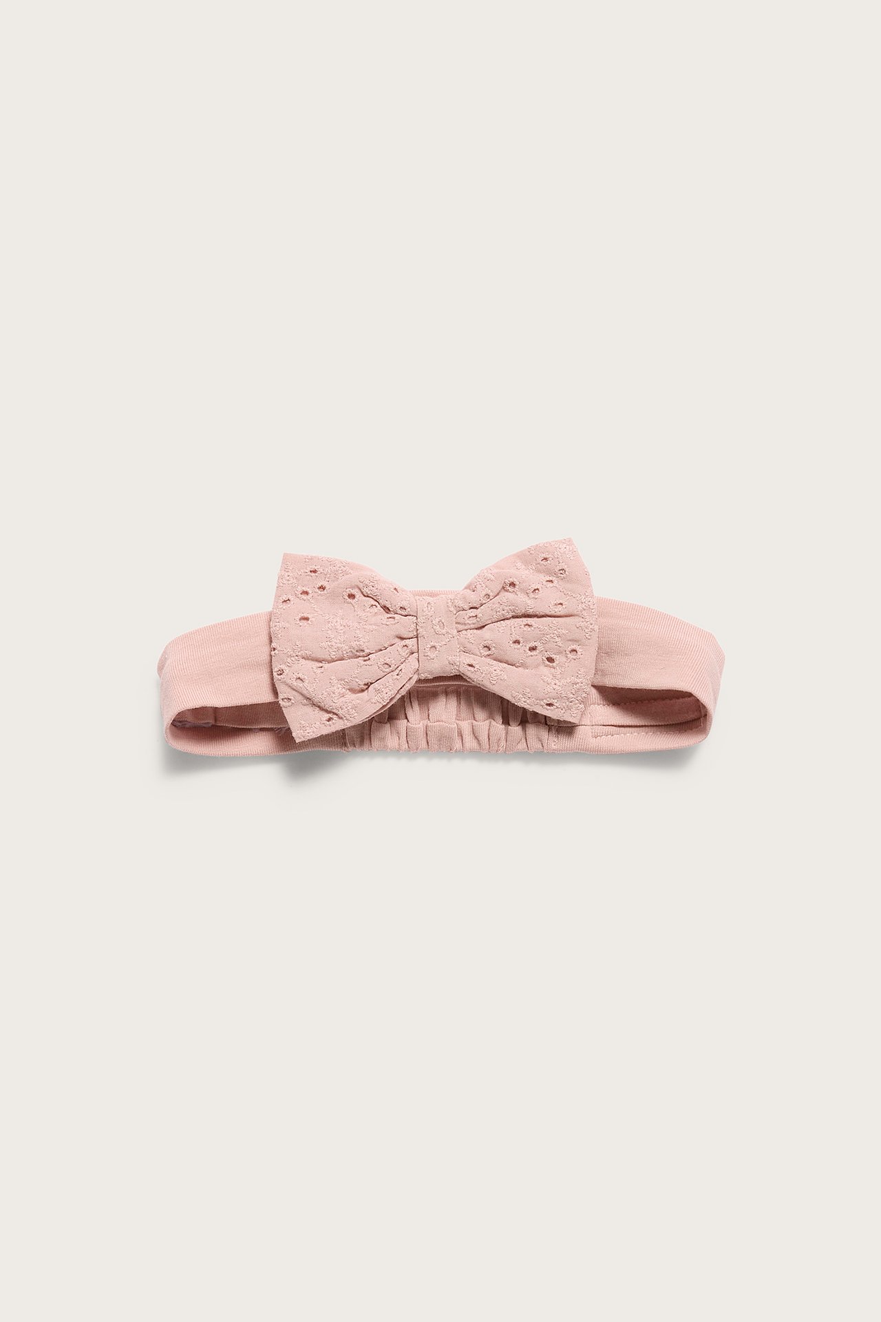Vorderansicht eines rosa Baby-Haarbands mit einer Lochstickerei-Schleife.