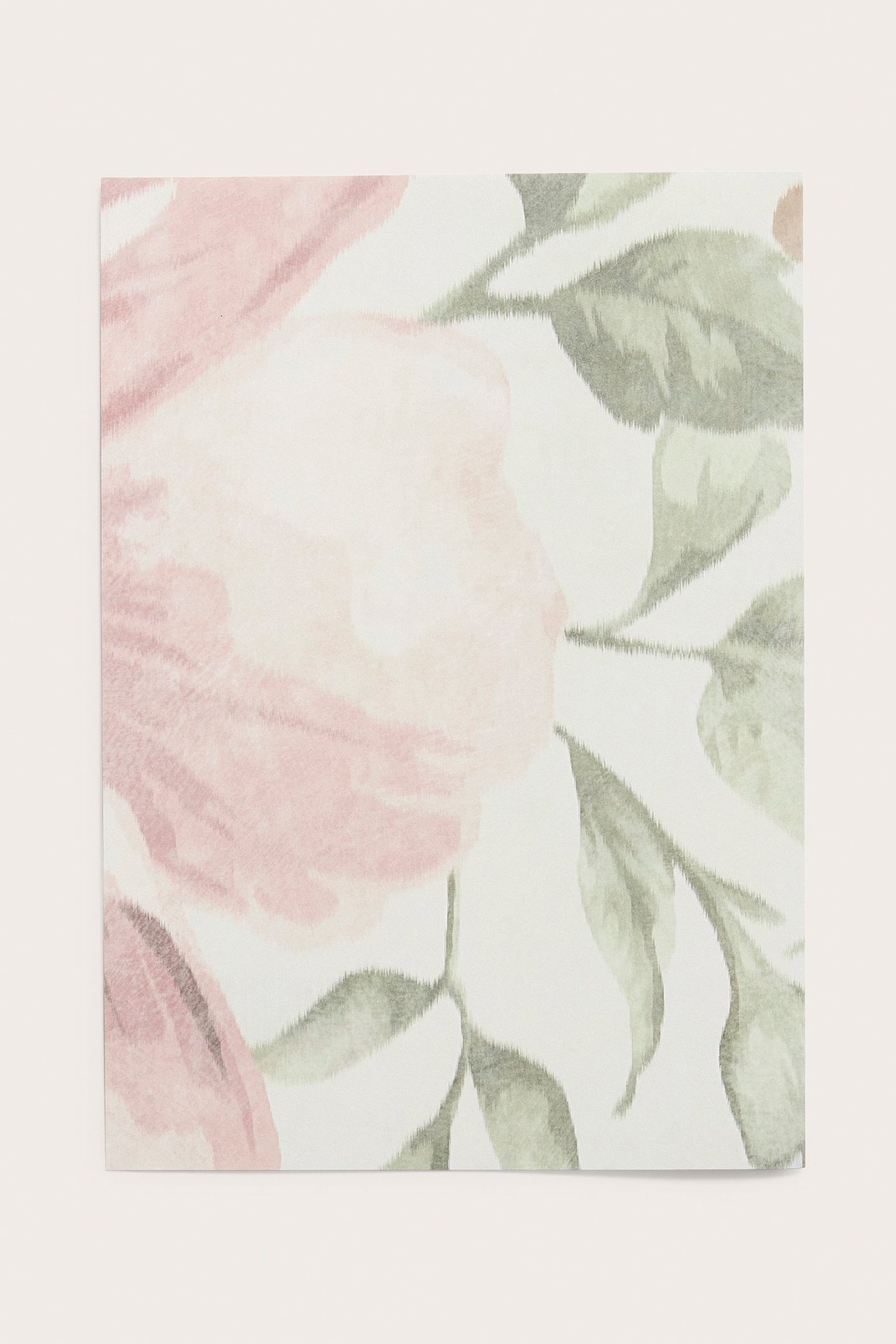 Nahaufnahme einer beigen Papiertapetenprobe mit rosa und grünem Blumenmuster.