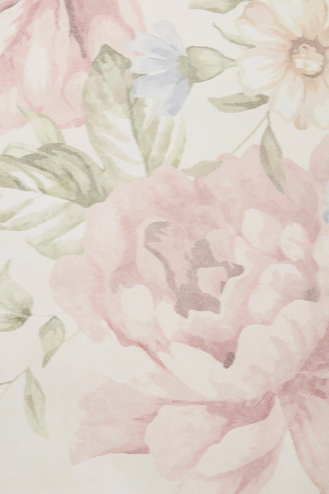 Nahaufnahme einer beigen Papiertapete mit floralem Muster in Rosa, Grün und Hellblau.