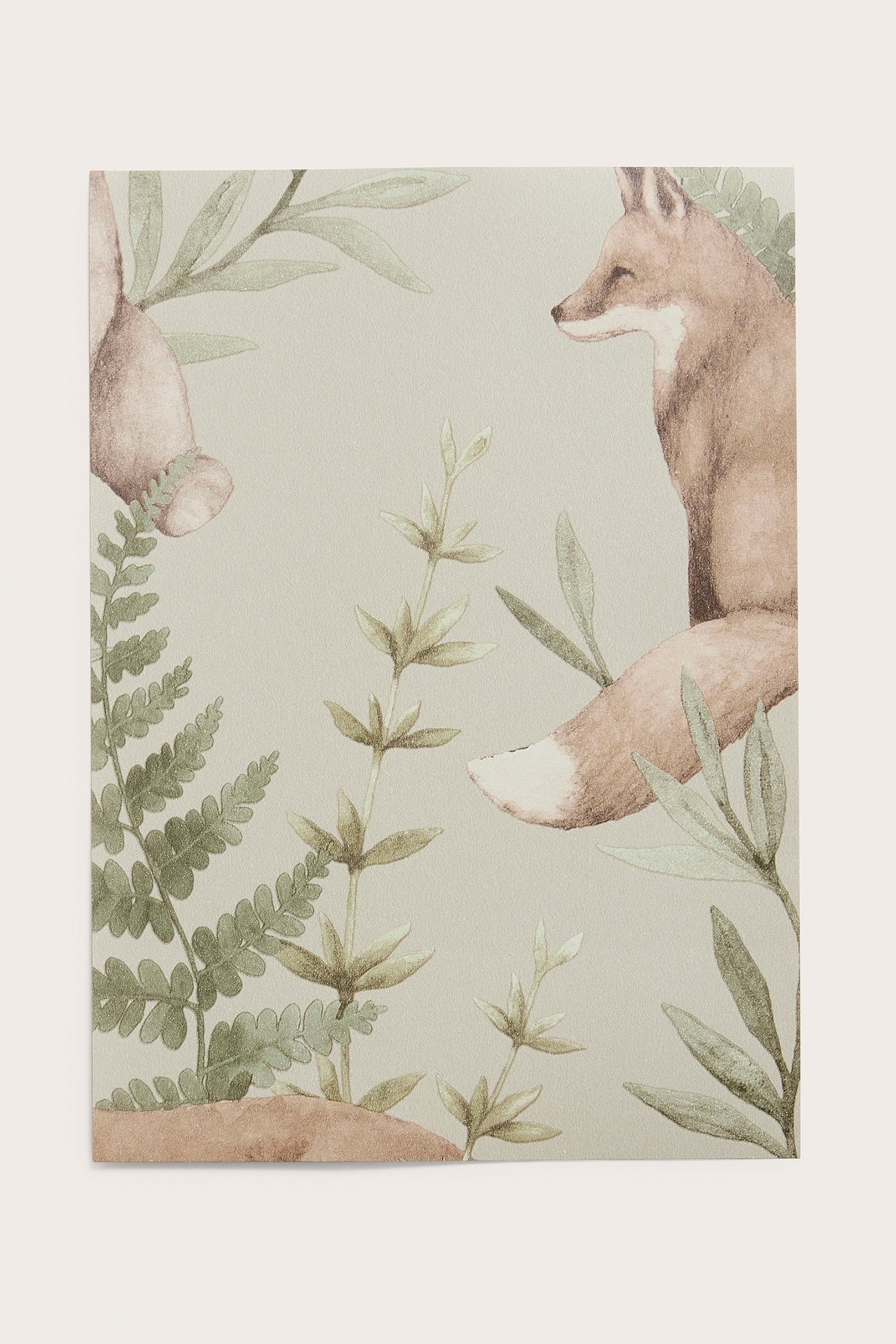 Nahaufnahme einer beigen Vliestapetenprobe mit Muster aus Fuchs, Teil eines Bären und grünen Waldpflanzen.