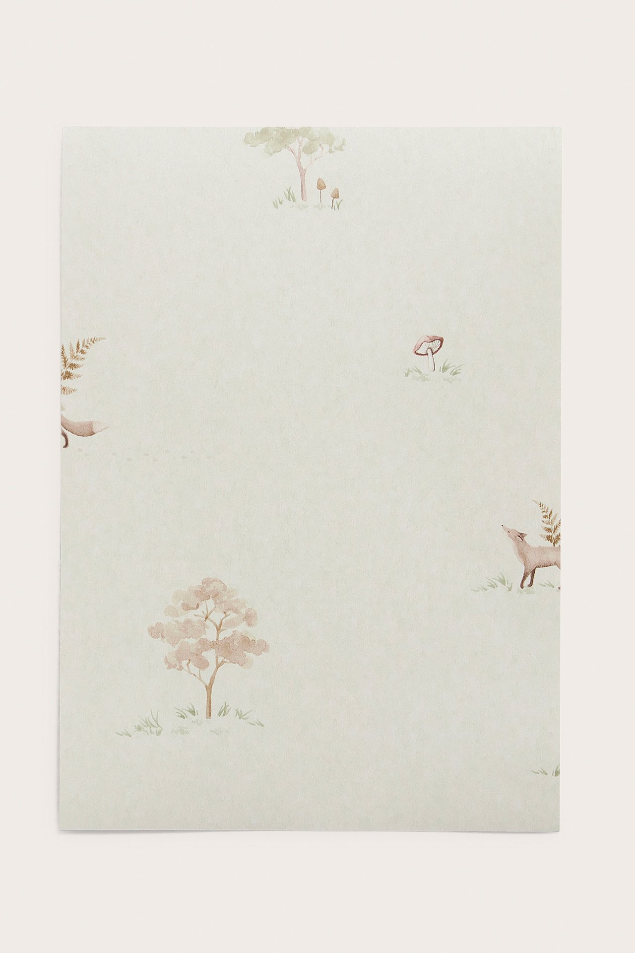 Front view of a beige wallpaper sample with a watercolor pattern of small foxes, trees, and mushrooms.