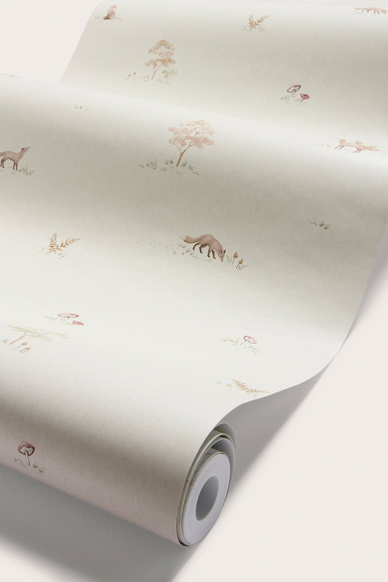 Nahaufnahme einer beigen Papiertapetenrolle mit sich wiederholendem Muster aus kleinen Füchsen, Bäumen und Pilzen.