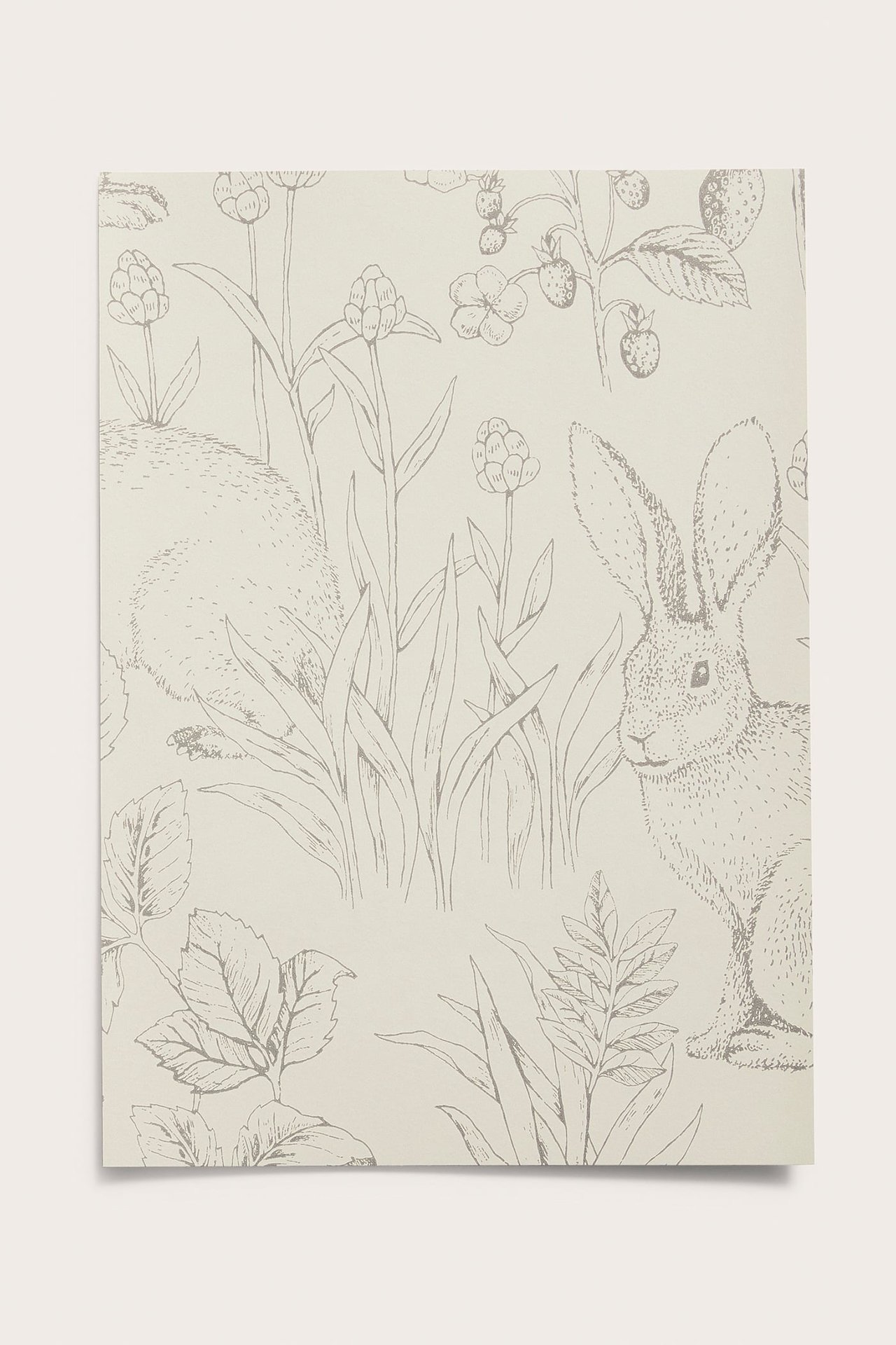 Vorderansicht einer beigen Vliestapetenprobe mit grauem Waldmuster, das Kaninchen, Blumen und Erdbeeren zeigt.