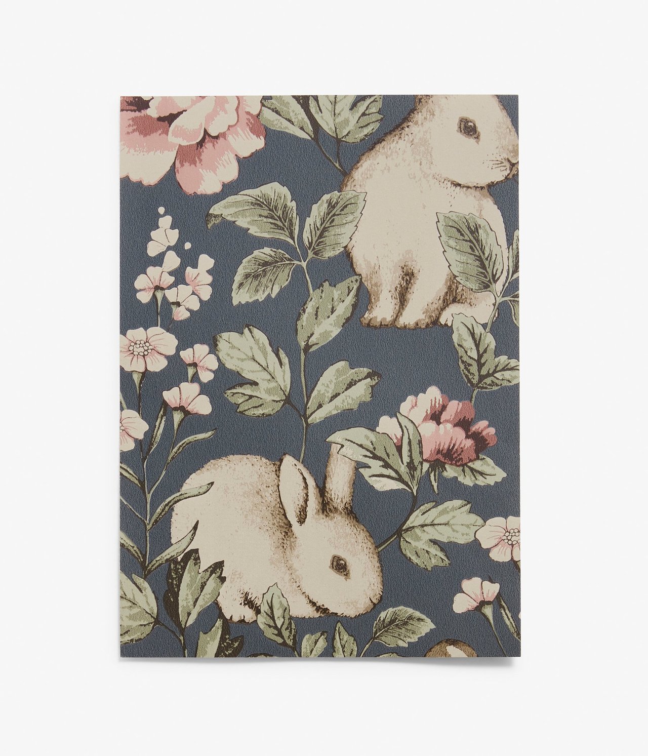Vorderansicht einer blauen Vliestapetenprobe mit Muster aus beigen Hasen und rosa Blumen.