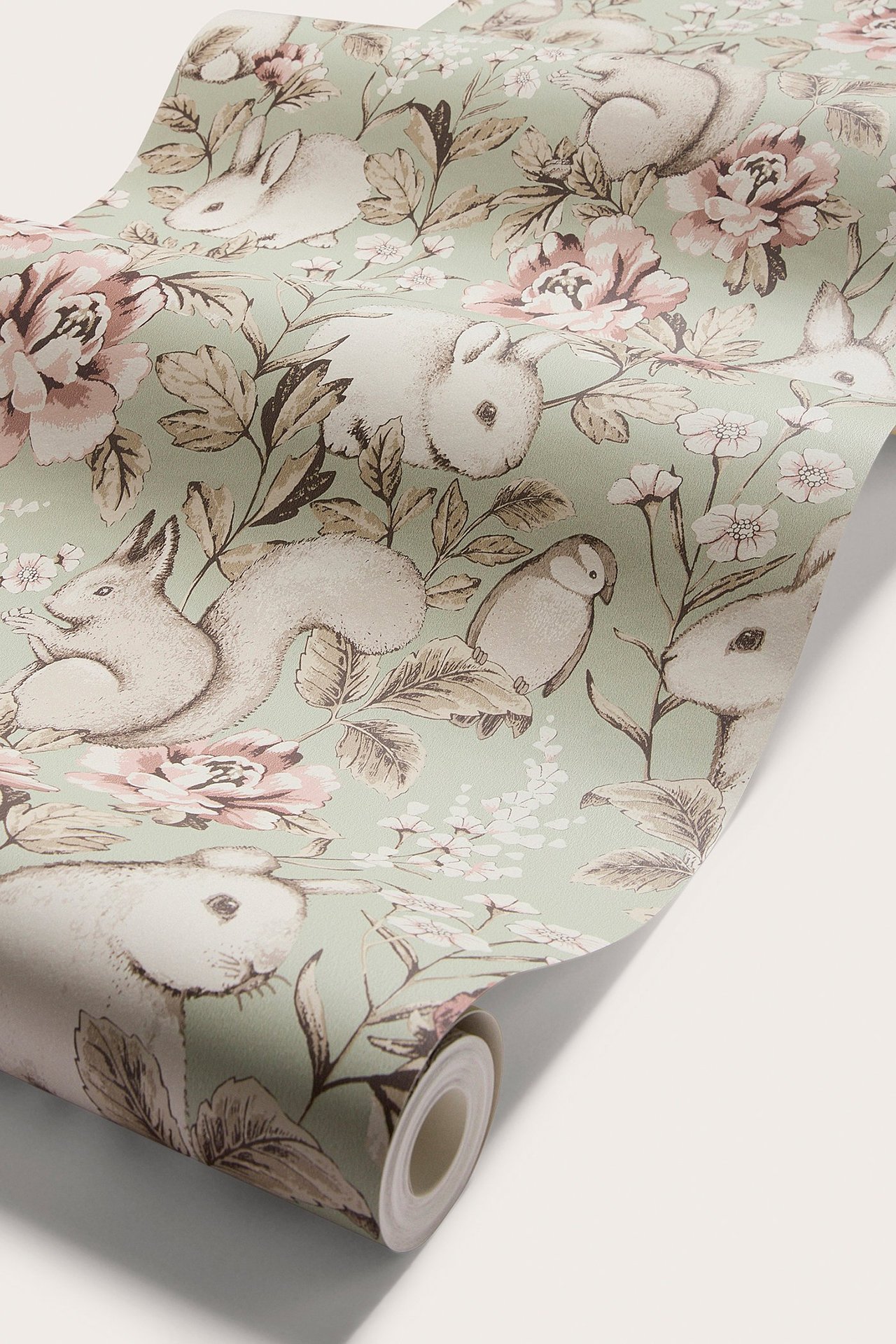 Nahaufnahme von grüner Vliestapete mit Muster aus rosa Blumen, Kaninchen, Eichhörnchen und Vögeln.