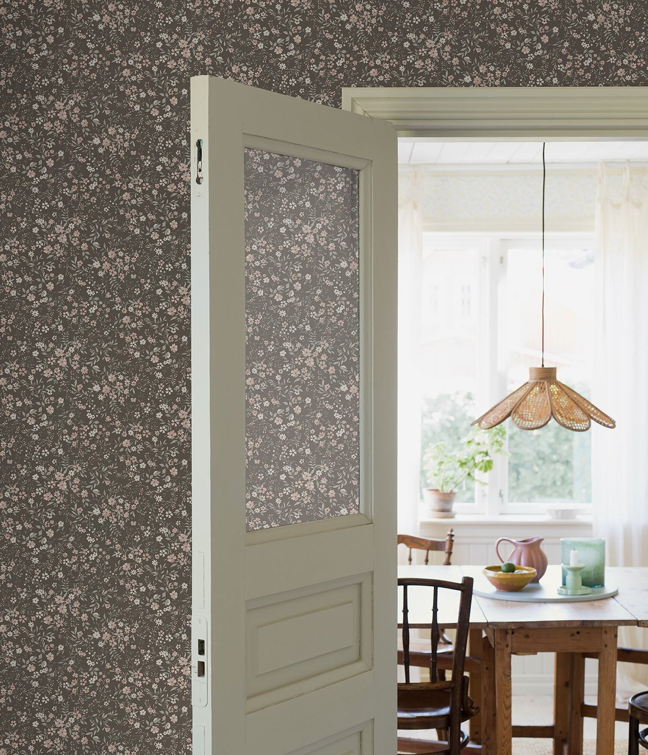 Umweltansicht einer braunen Vliestapete mit kleinem rosa-weißem Blumenmuster.