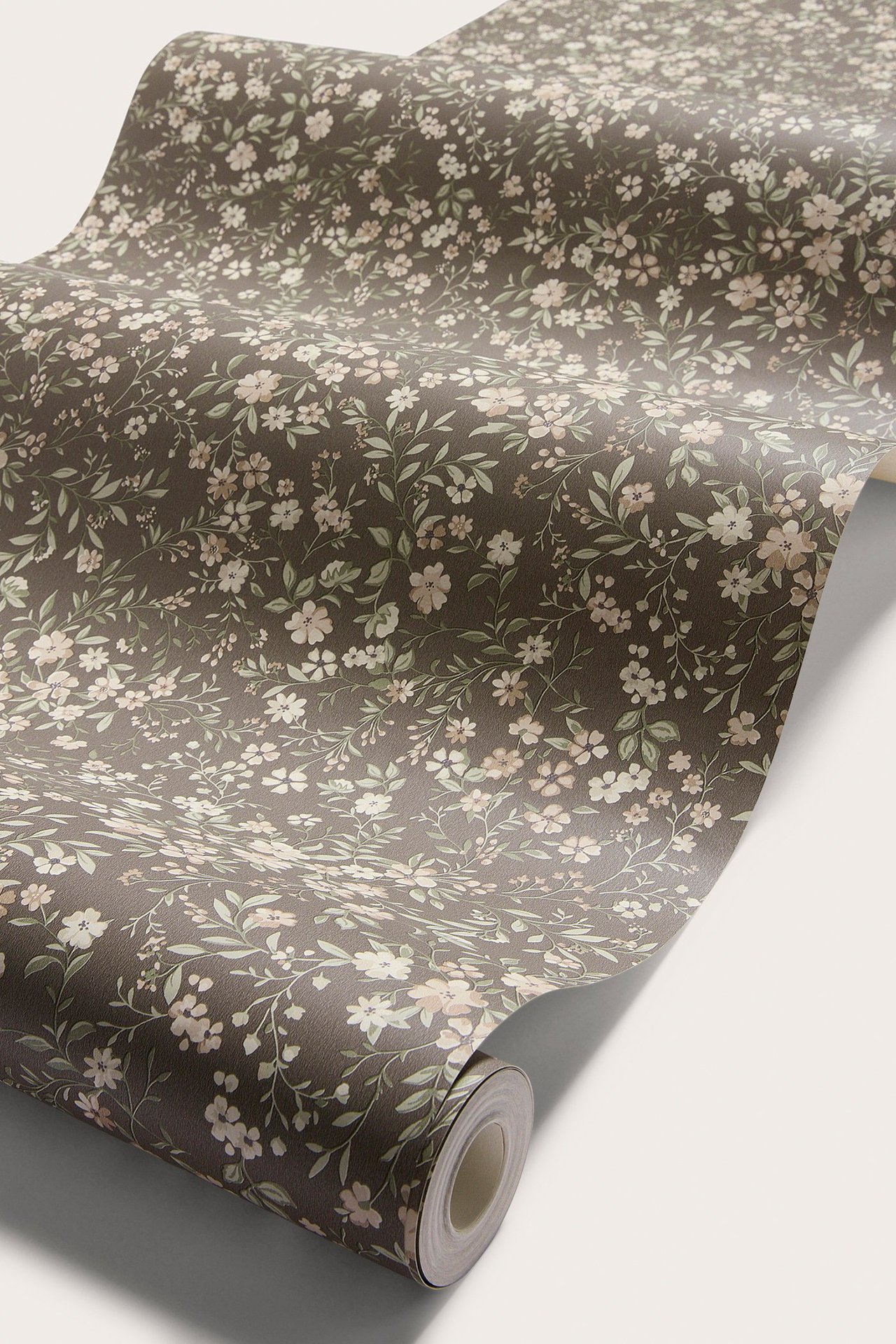 Schräge Ansicht brauner Papiertapete mit kleinem hellem Blumenmuster, wird abgerollt.