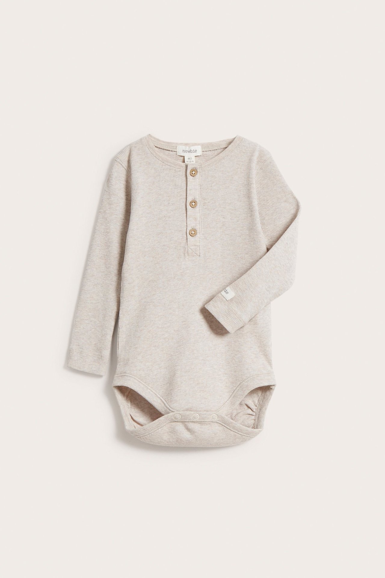 Front view of a baby's beige melange ribbed long-sleeved bodysuit with a button placket and snap fasteners.