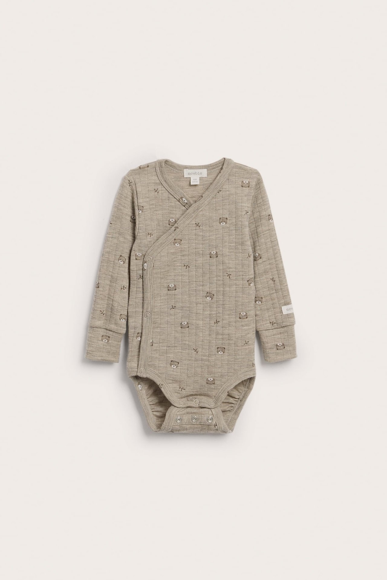 Vorderansicht eines langärmligen beigen Babybodys mit Wickelstil, gesteppter Textur und Bärendruck.