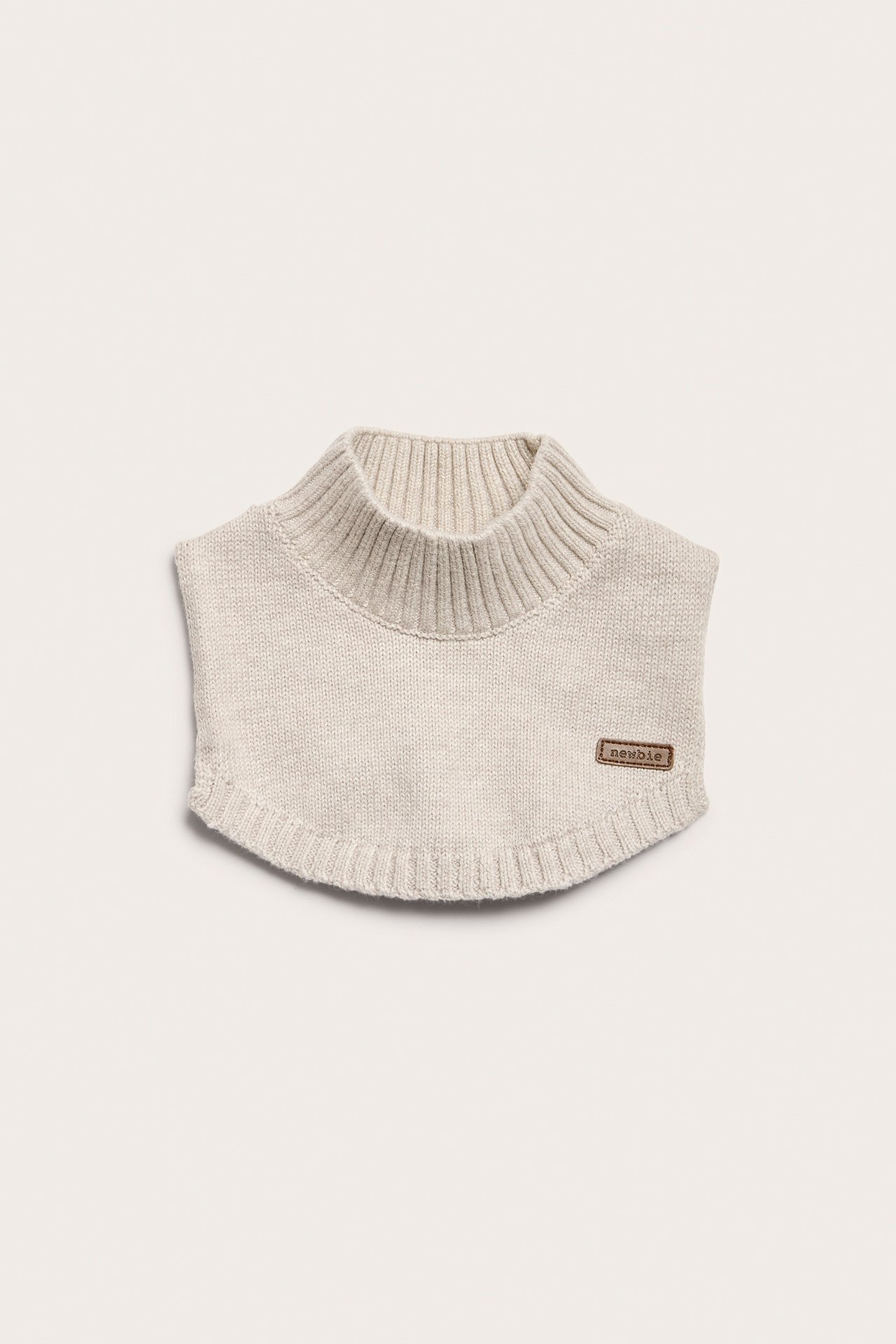 Front view of a light beige knitted baby dickey with a ribbed mock neck and small label.