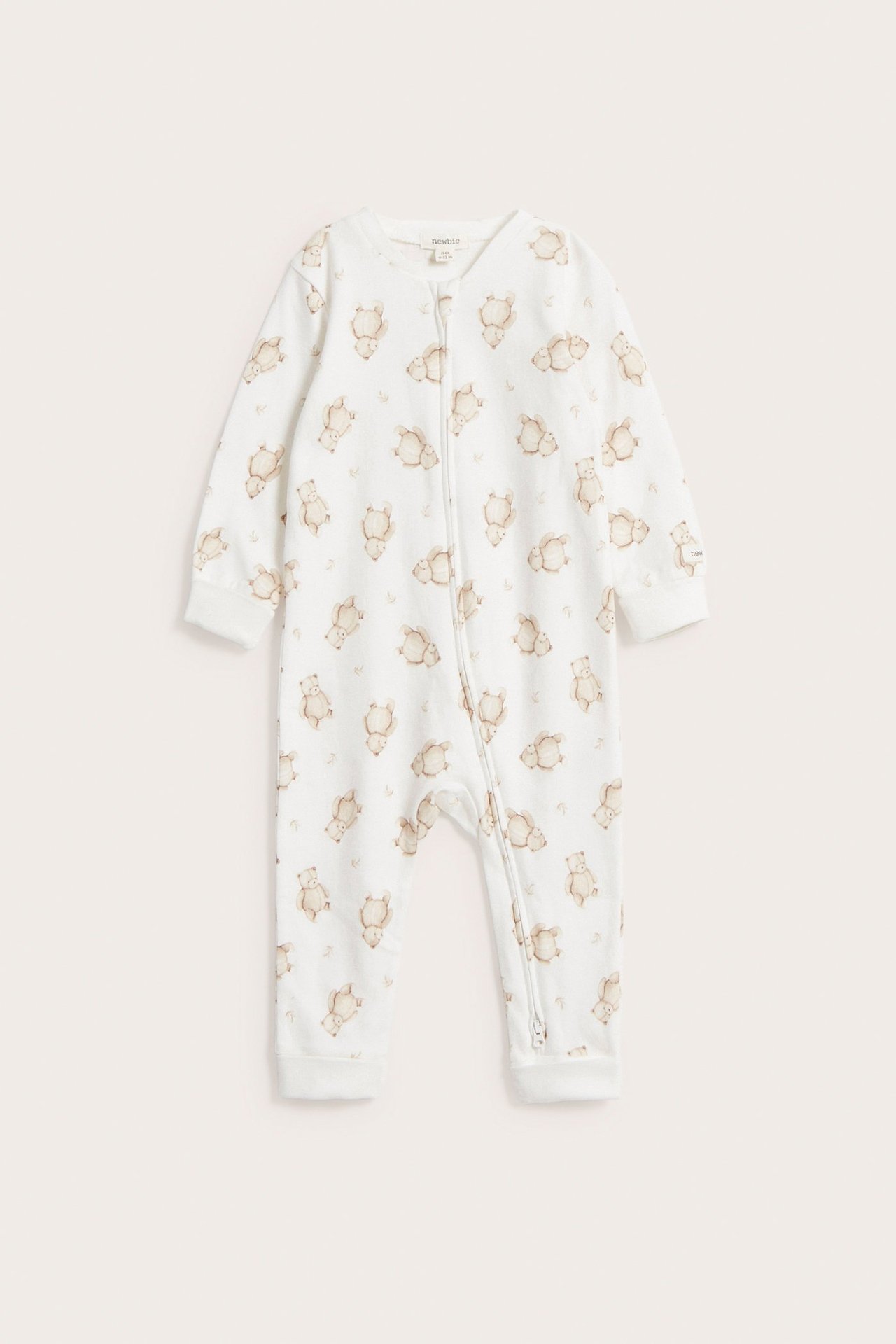 Front view: Offwhite baby cotton sleepsuit with brown teddy bear pattern and a two-way zip.