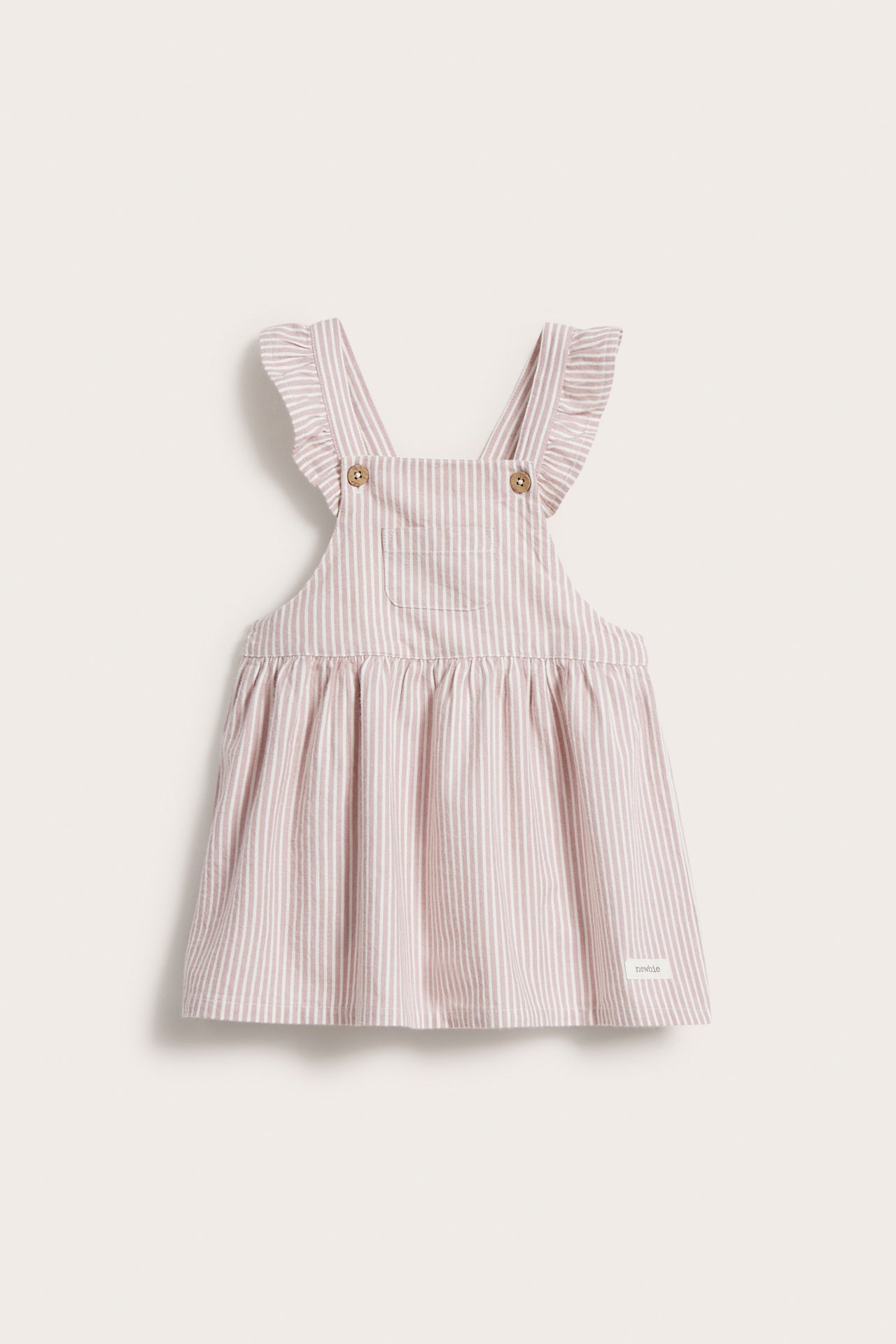 Vorderansicht eines babyrosa-weiß gestreiften Latzkleides mit Rüschen-Trägern und Brusttasche.