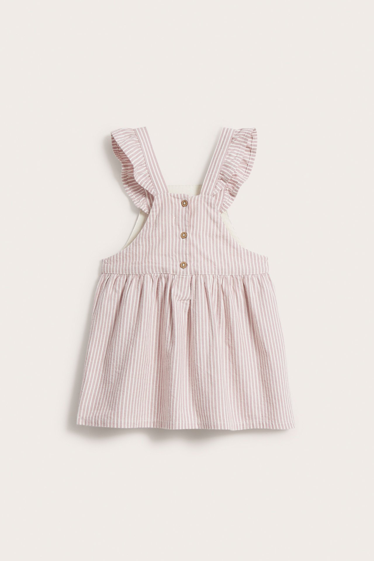 Rückansicht eines gestreiften rosa Baby-Latzkleides mit Rüschen-Trägern und Knopfverschluss hinten.