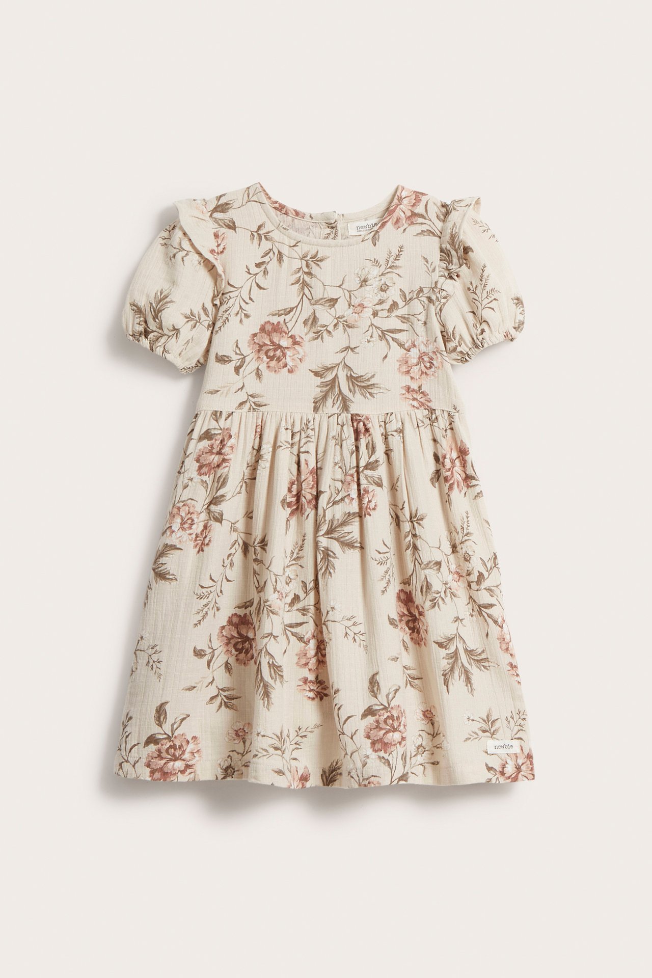 Front view of a kid's beige floral cotton dress with short puff sleeves and shoulder ruffles.