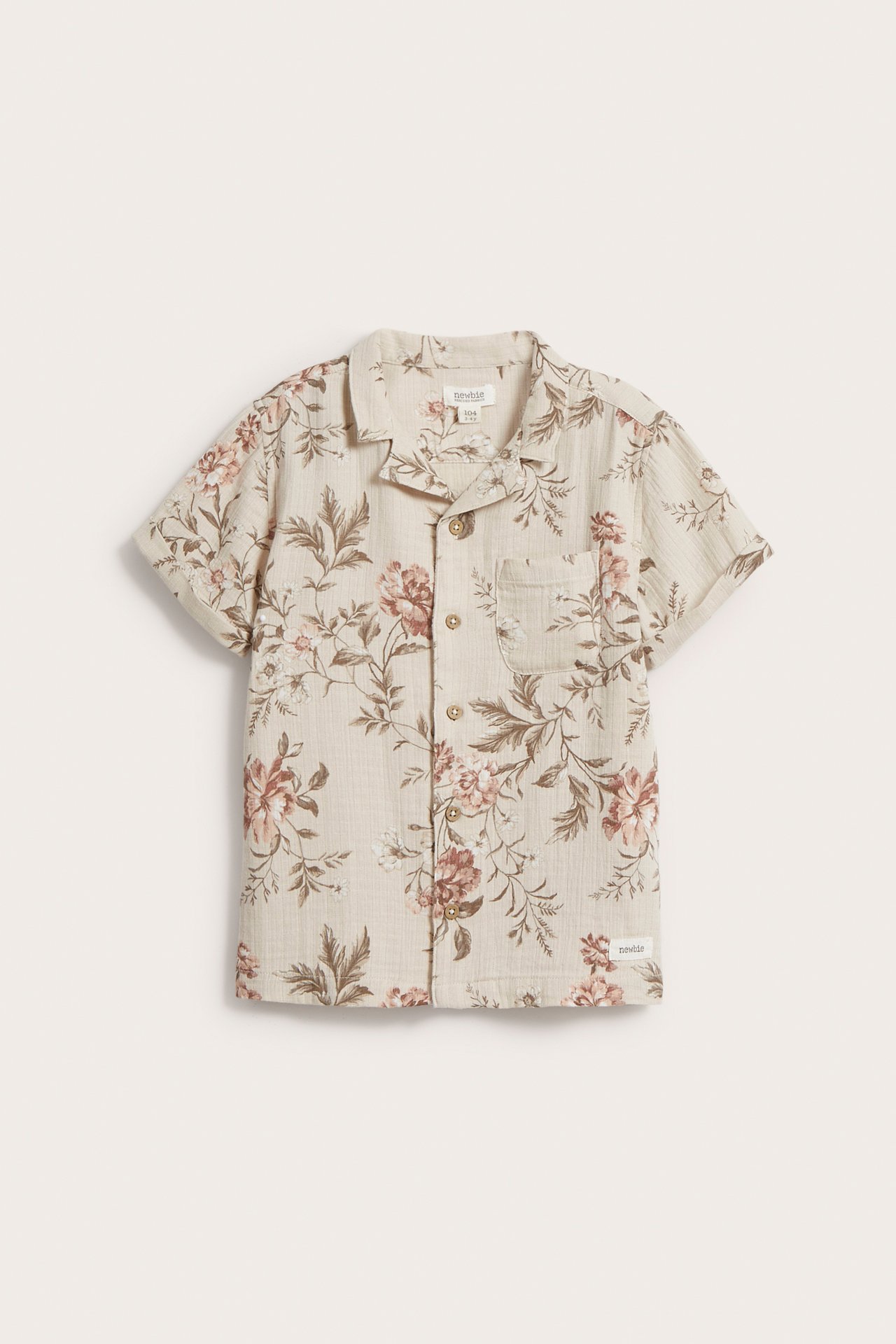 Vorderansicht eines beigen kurzärmeligen Baumwollhemdes mit rosa-braunem Blumenmuster, Kragen und Knöpfen vorne.