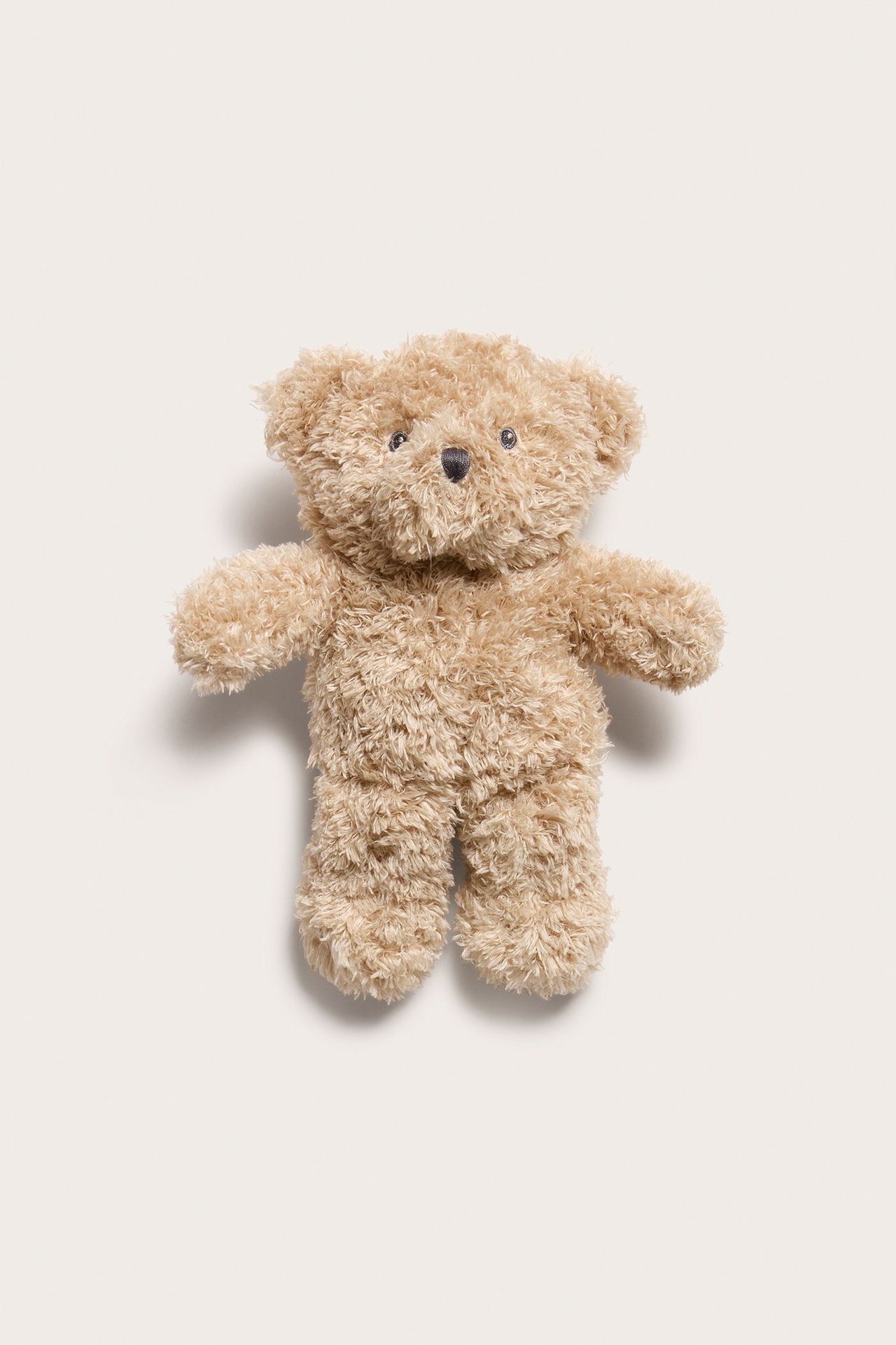 Front view of a soft, cuddly beige teddy bear with a fluffy texture, approximately 23 cm tall.
