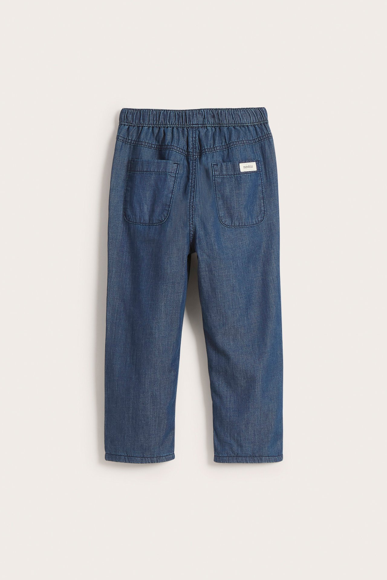 Back view of kid's blue cotton jeans with an elasticated waist and two back pockets.