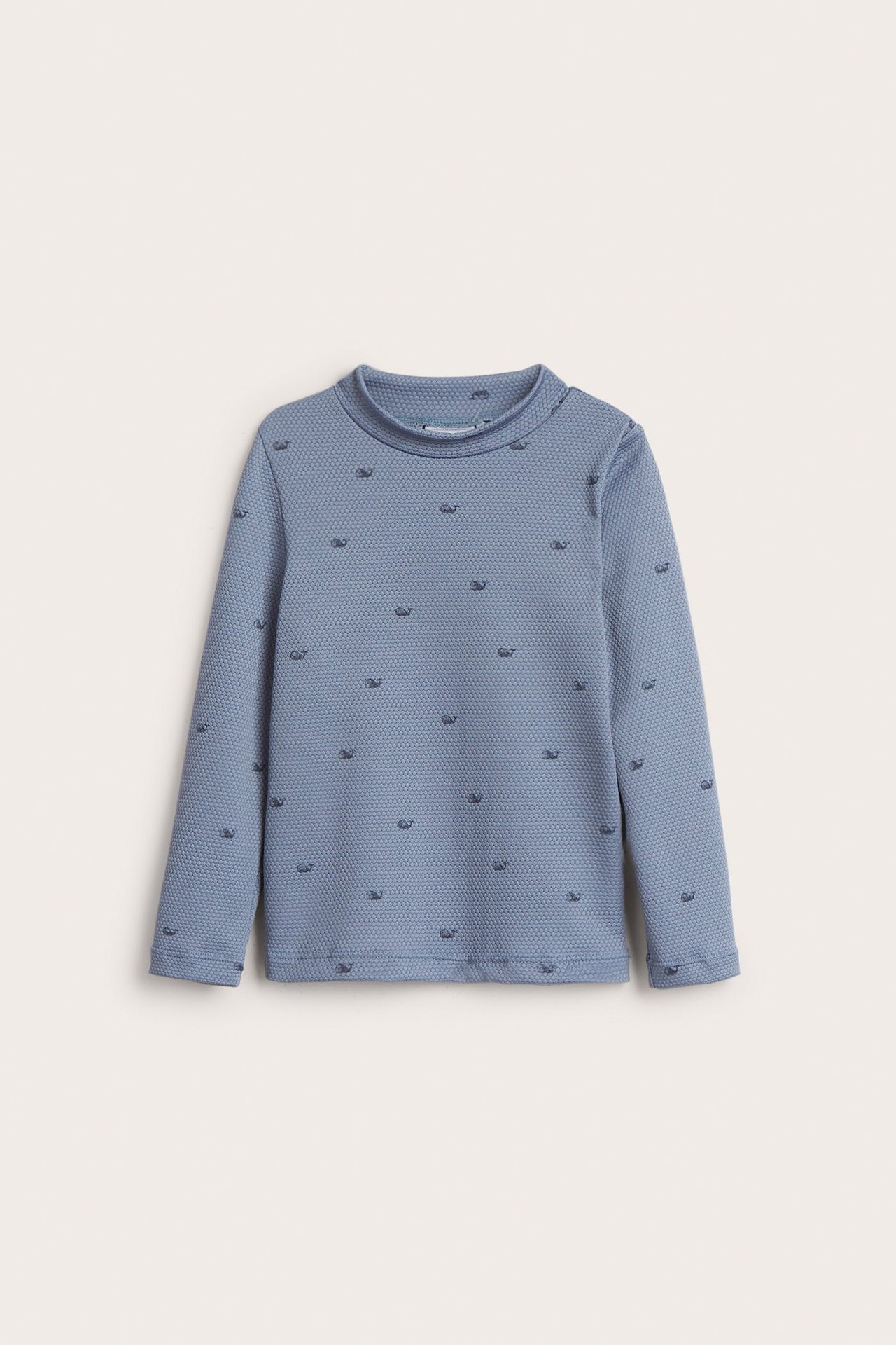 Vorderansicht eines blauen langärmeligen Kinder-UV-Oberteils mit strukturierter Oberfläche und kleinen Fischen.