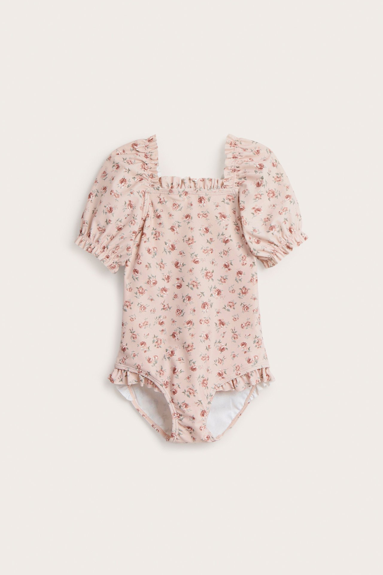 Vorderansicht eines babyrosa Blumenbadeanzugs mit Puffärmeln und Rüschen an Hals und Beinöffnungen.
