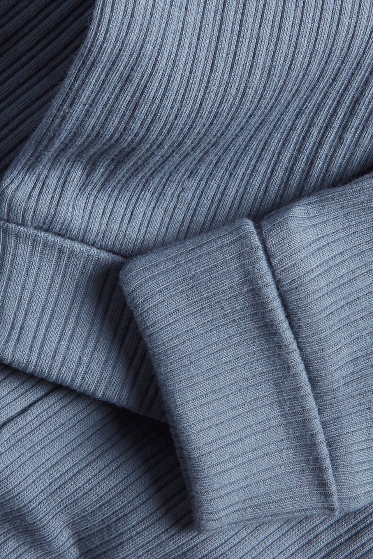 Close-up of light blue ribbed cotton blend leggings with a folded cuff.