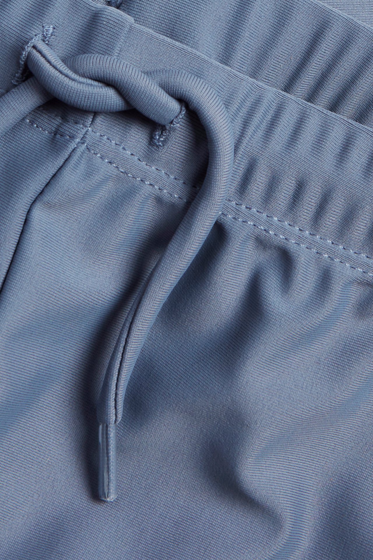 Close-up of blue solid UV swim shorts with a drawstring waistband.