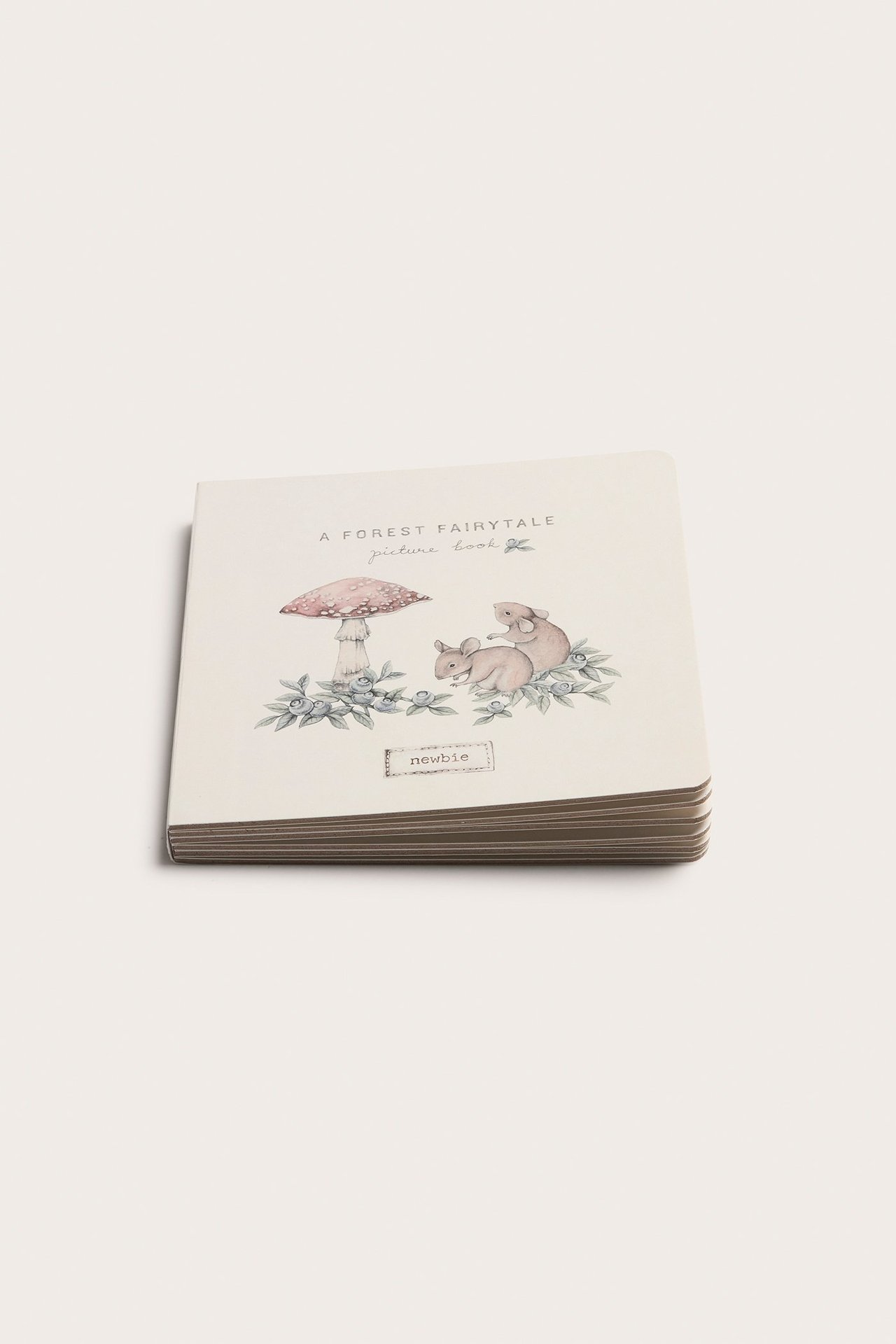 Schräge Vorderansicht eines cremefarbenen, gemusterten Hardcover-Bilderbuchs mit Waldmärchen-Illustration.