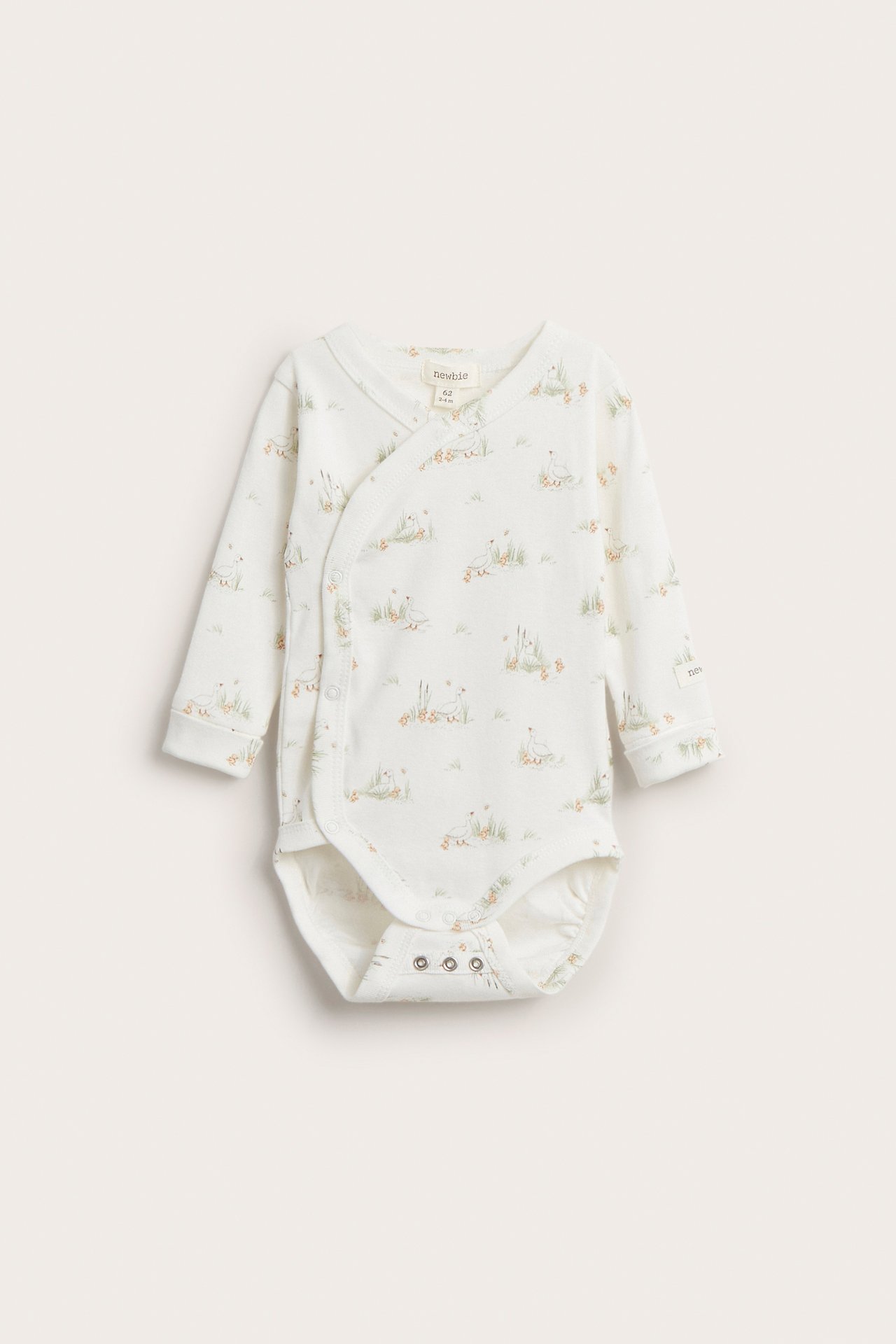 Vorderansicht: Off-white gerippter Baby-Wickelbody aus Bio-Baumwolle mit Gänse-Print und Druckknöpfen.