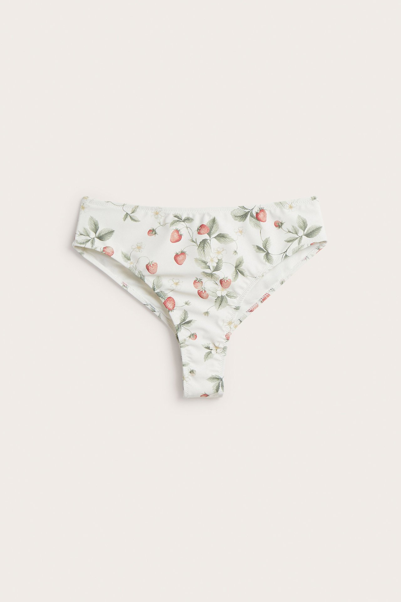 Front view of an off-white women's bikini thong with a red strawberry floral pattern.
