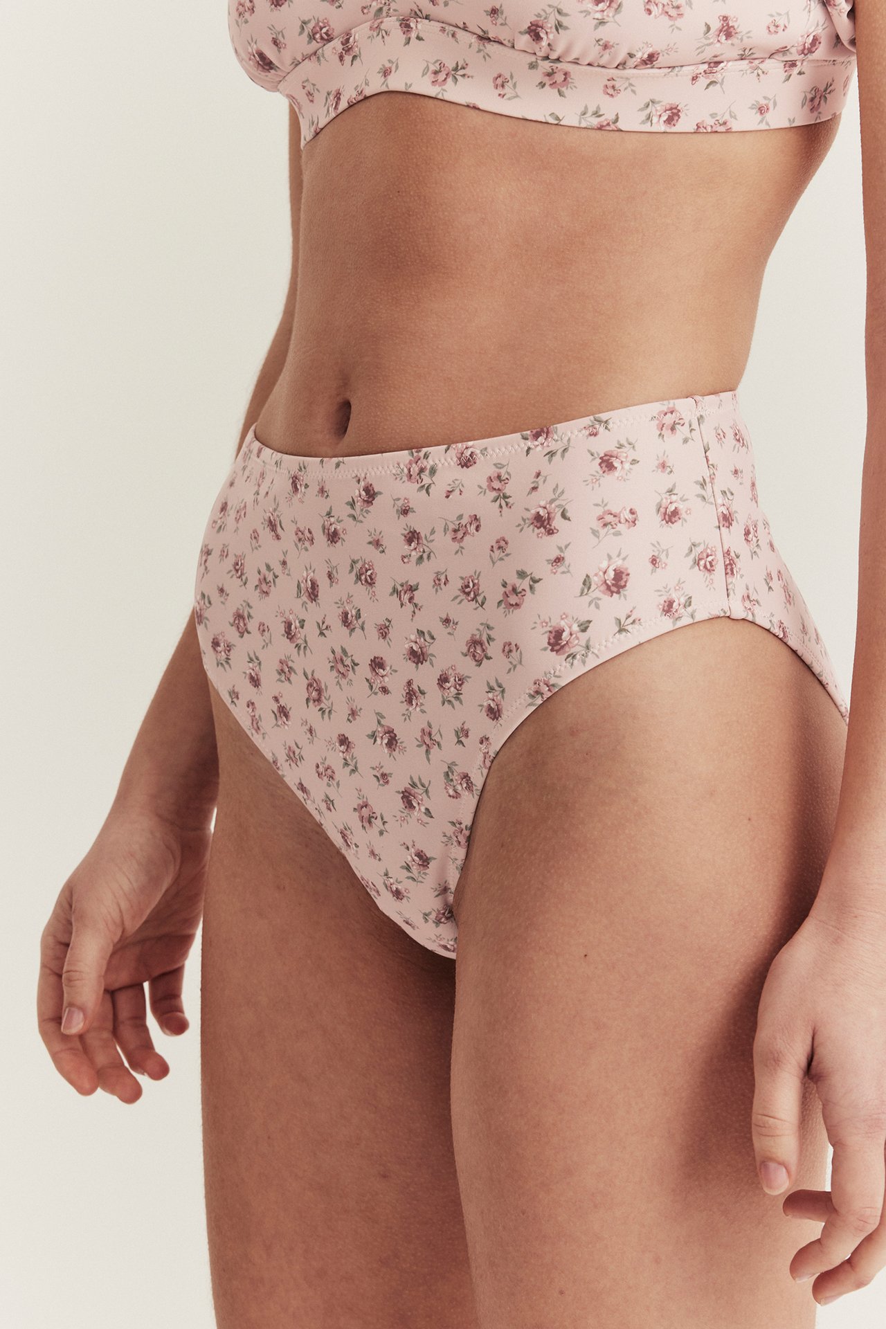 Nahaufnahme, Seitenansicht einer Frau in einem rosa hochtaillierten Blumen-Bikinihöschen und passendem Oberteil.