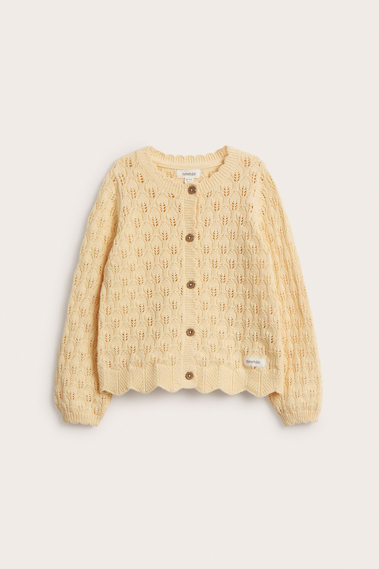 Front view of a yellow pattern-knitted cotton baby cardigan with brown buttons and scalloped edges.