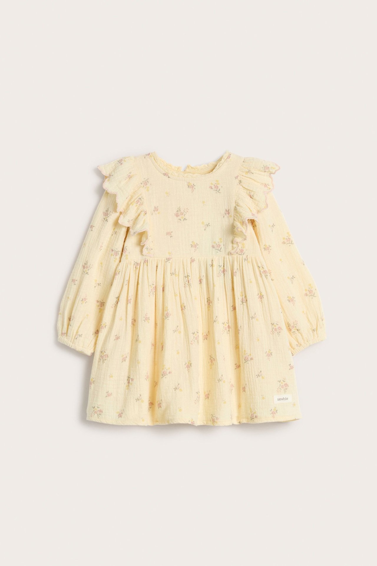Front view of a kid's yellow crumpled floral cotton dress with ruffles, puff sleeves, and back buttons.
