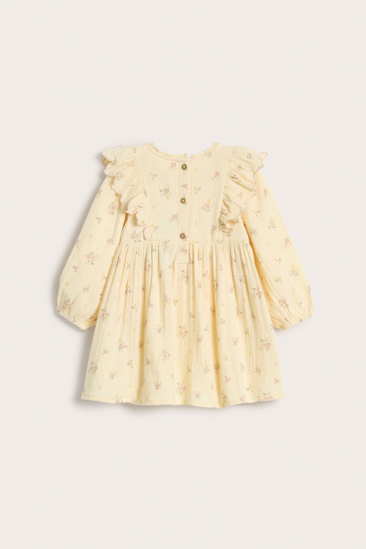 Front view of a kid's yellow floral organic cotton dress with puff sleeves, ruffles, and back buttons.