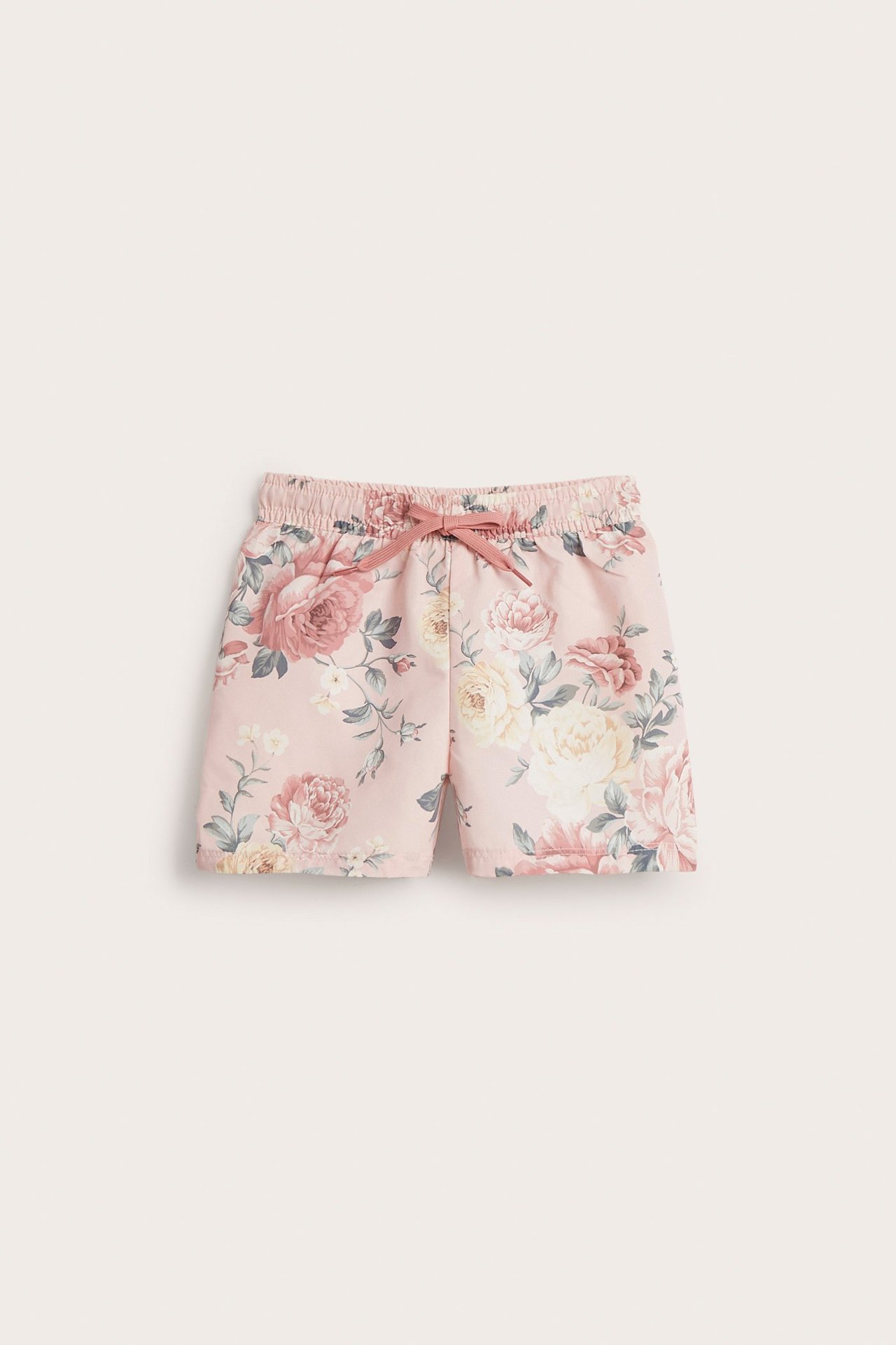 Vorderansicht rosa geblümter Badeshorts für Baby/Kind mit elastischem Bund und rosa Kordelzug.