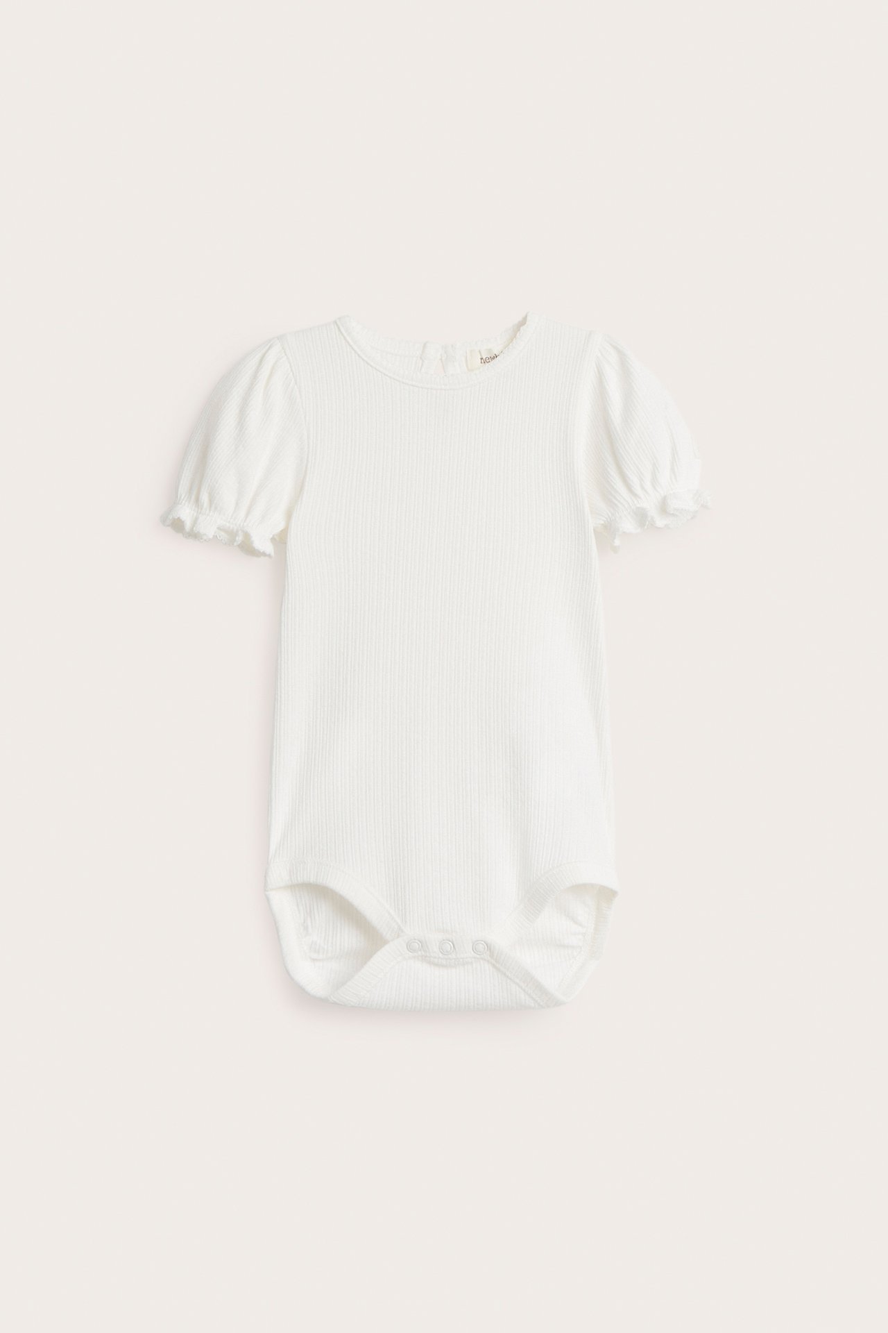 Front view of an off-white ribbed jersey baby bodysuit with short puff sleeves and crotch snap fasteners.