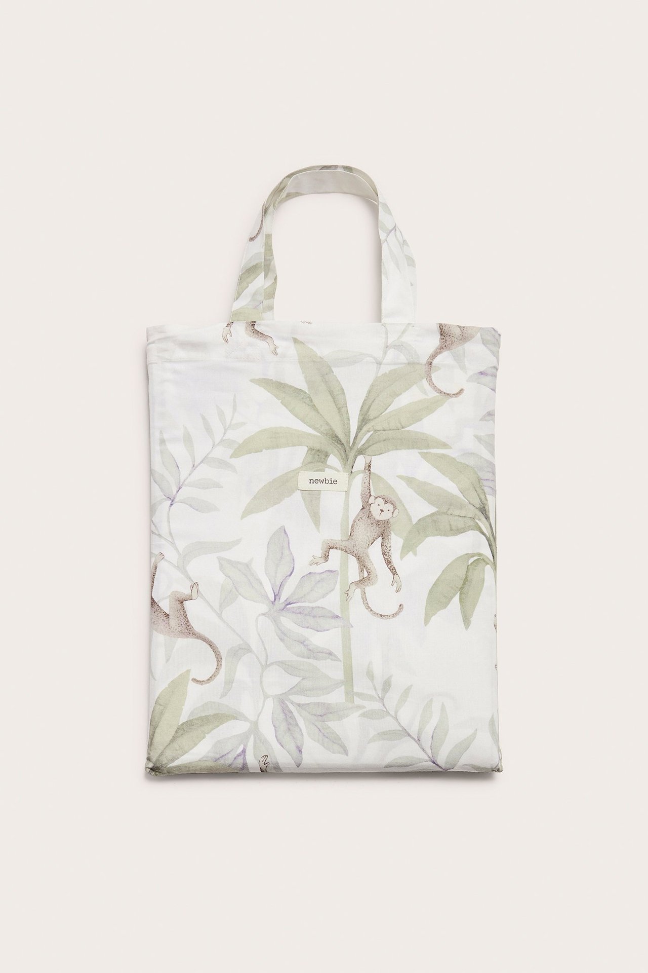 Vorderansicht eines cremefarbenen Baumwoll-Bettwäschesets in passender Stofftasche mit Dschungelmuster.