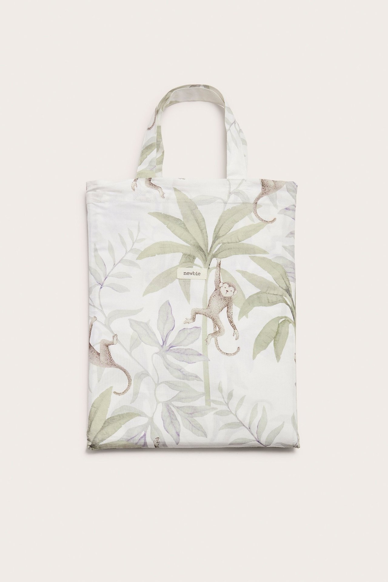 Vorderansicht eines cremefarbenen Baumwoll-Bettwäschesets in passender Stofftasche mit Dschungeltiermuster.