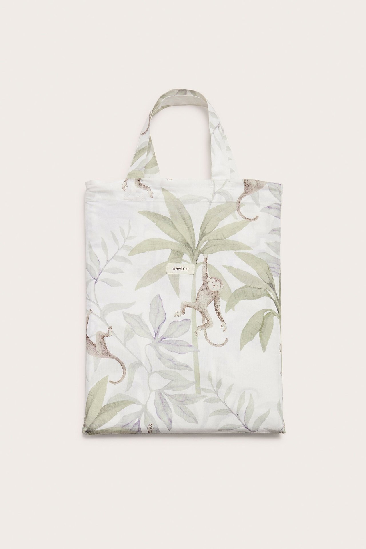 Vorderansicht: Off-weißes Baumwoll-Bettwäscheset mit Dschungelmuster aus Affen und Palmenblättern, als Tasche gefaltet.