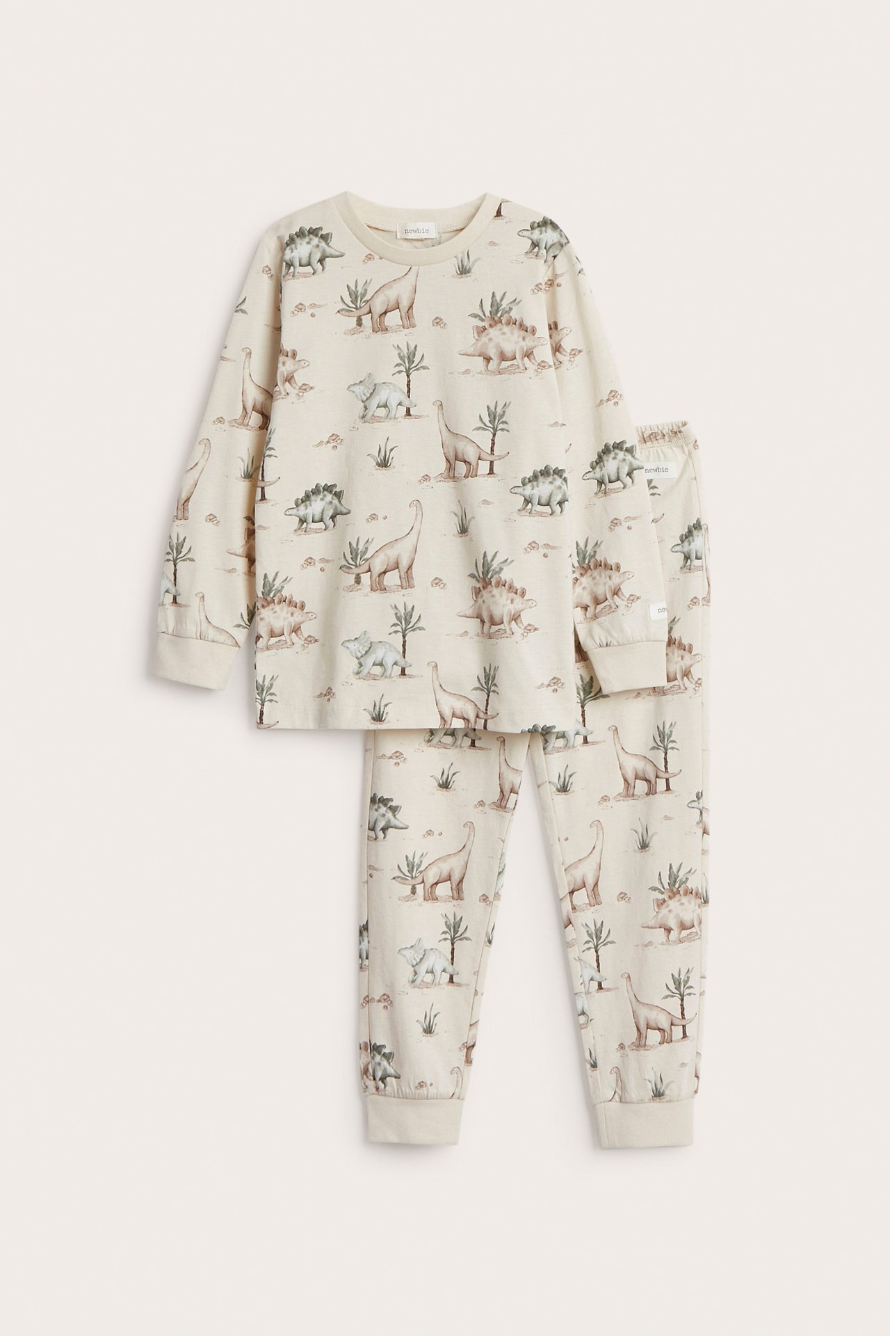Vorderansicht: Hellbeiger zweiteiliger Kinderpyjama aus Jersey mit Allover-Dinosaurier-Print.