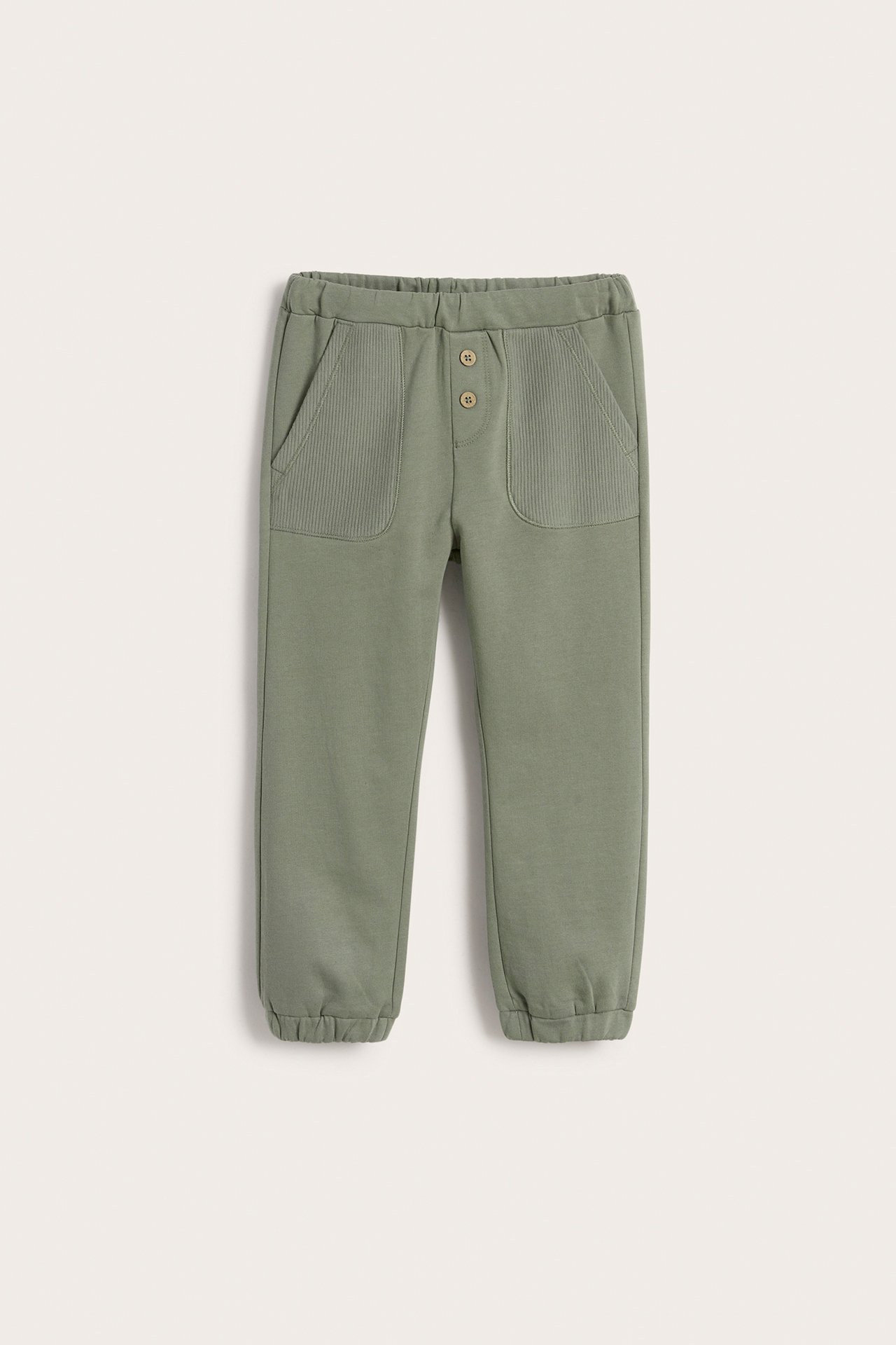 Vorderansicht einer dunkelgrünen Kinder-Jogginghose mit gerippten Taschen und Zierknöpfen.
