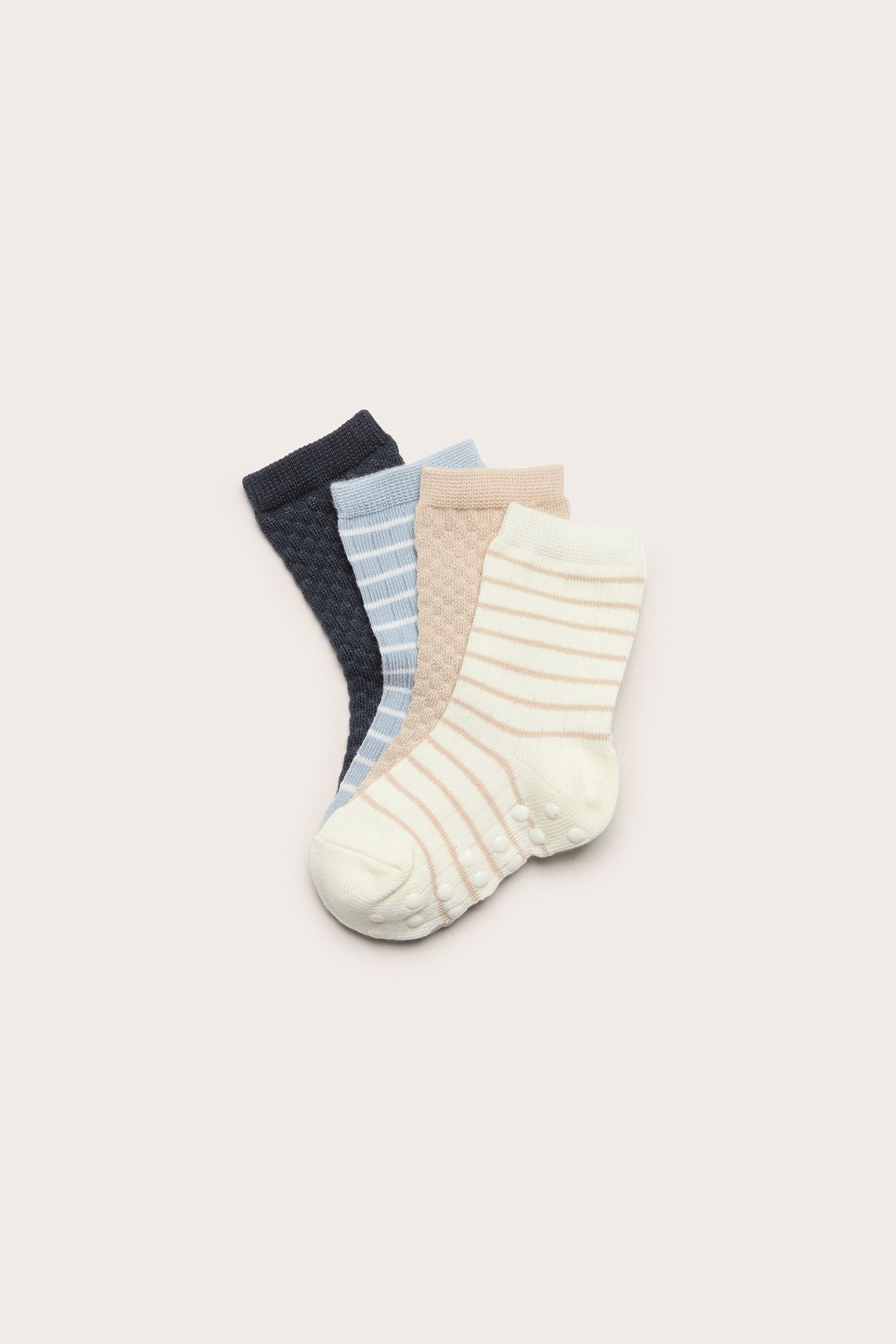 Top-down view of four baby socks: off-white striped, beige textured, light blue striped, and dark blue textured.