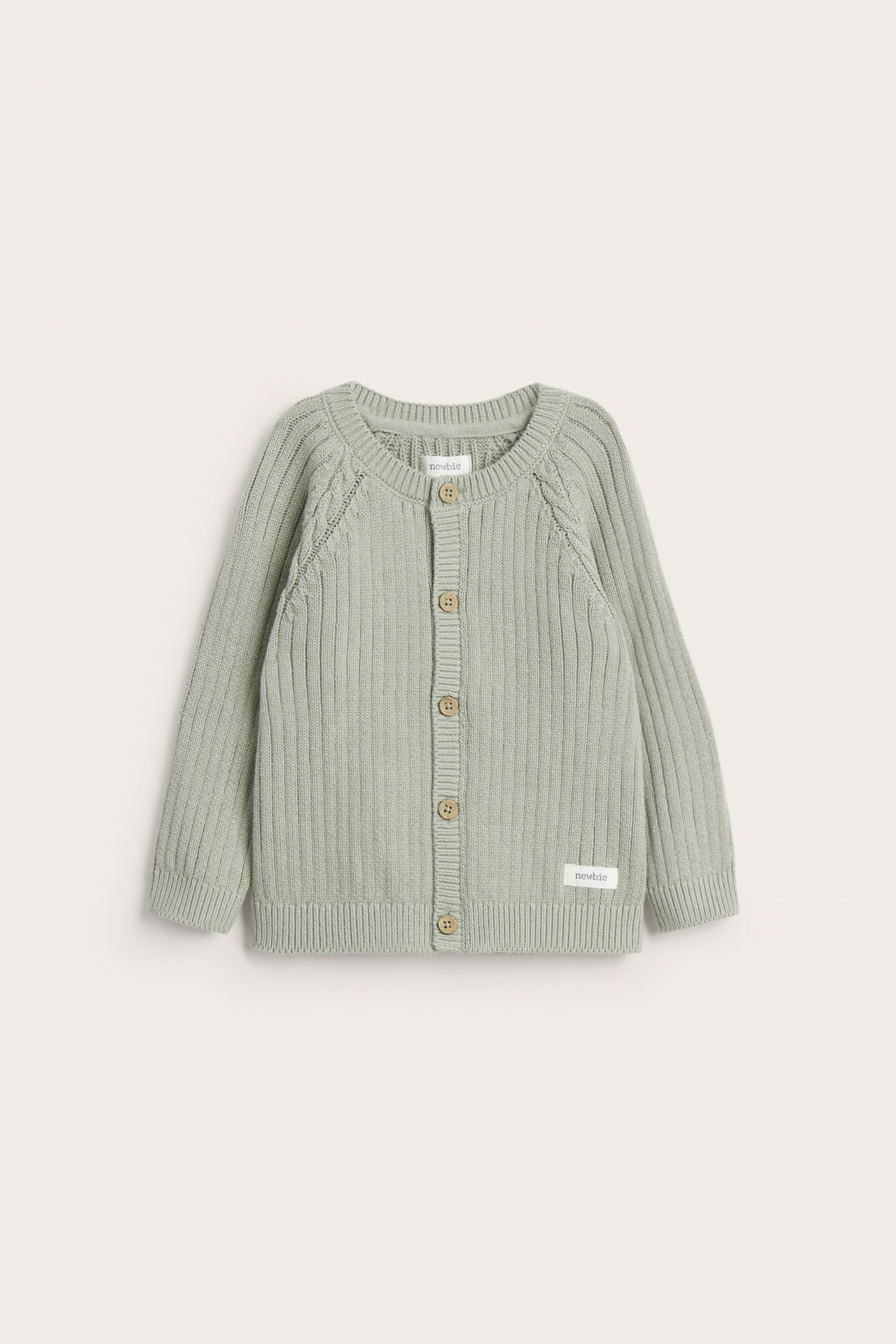 Vorderansicht: Baby-Cardigan aus hellgrüner Rippstrick-Baumwolle mit Zopfstrickärmeln und braunen Knöpfen.