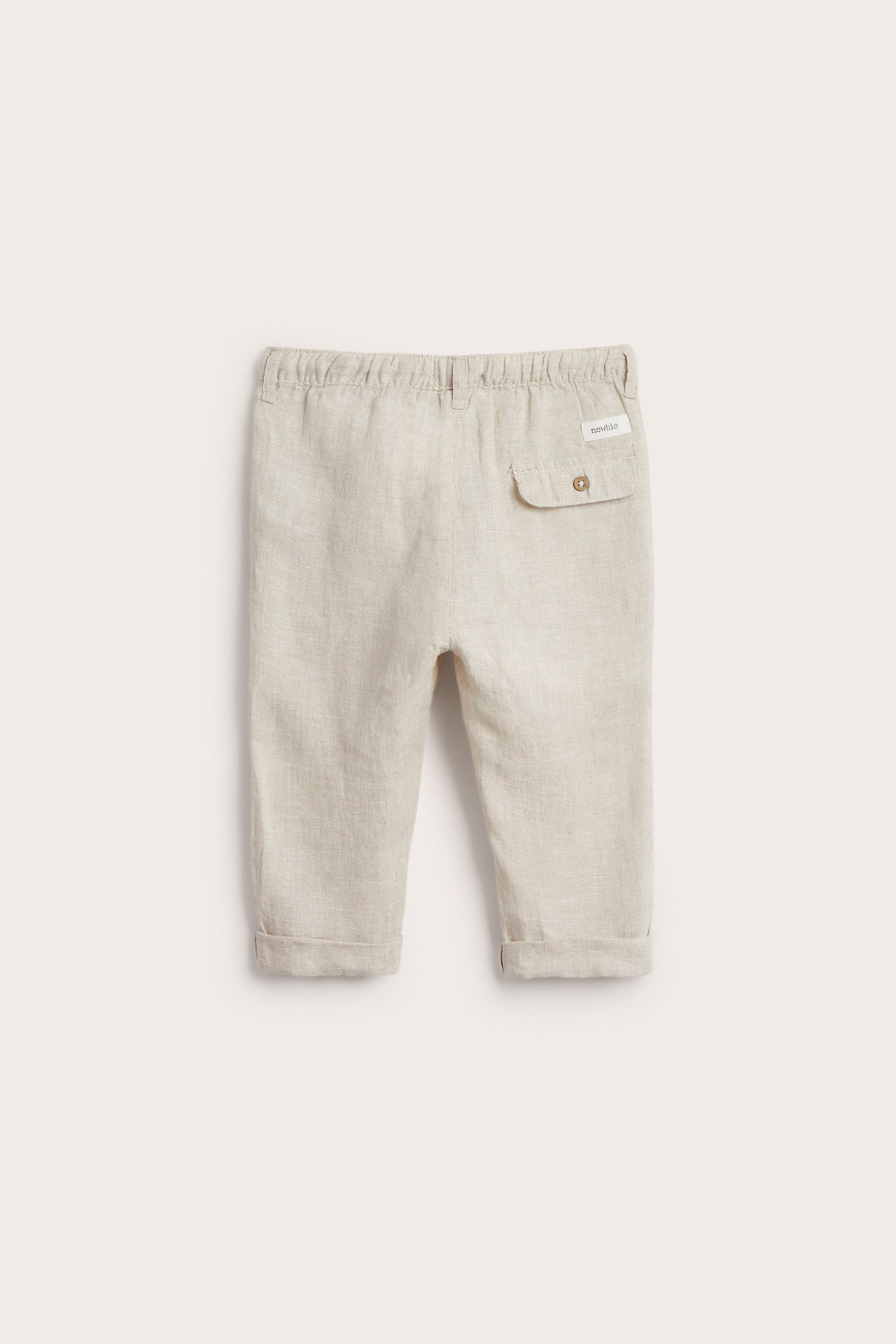 Rückansicht: hellbeige Leinenhose für Kinder mit Gummizug in der Taille und Ziertasche hinten.