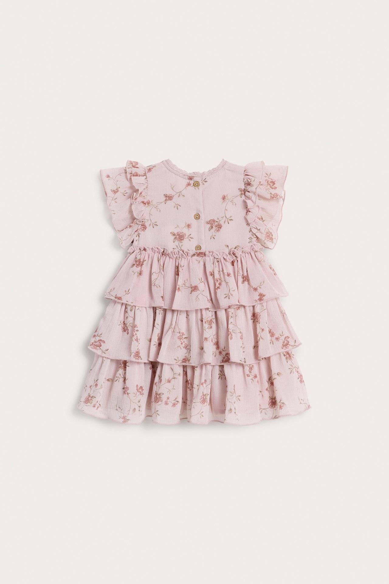 Vorderansicht eines babyrosa geblümten Chiffonkleides mit Rüschenärmeln, Stufenrock und Knöpfen vorne.