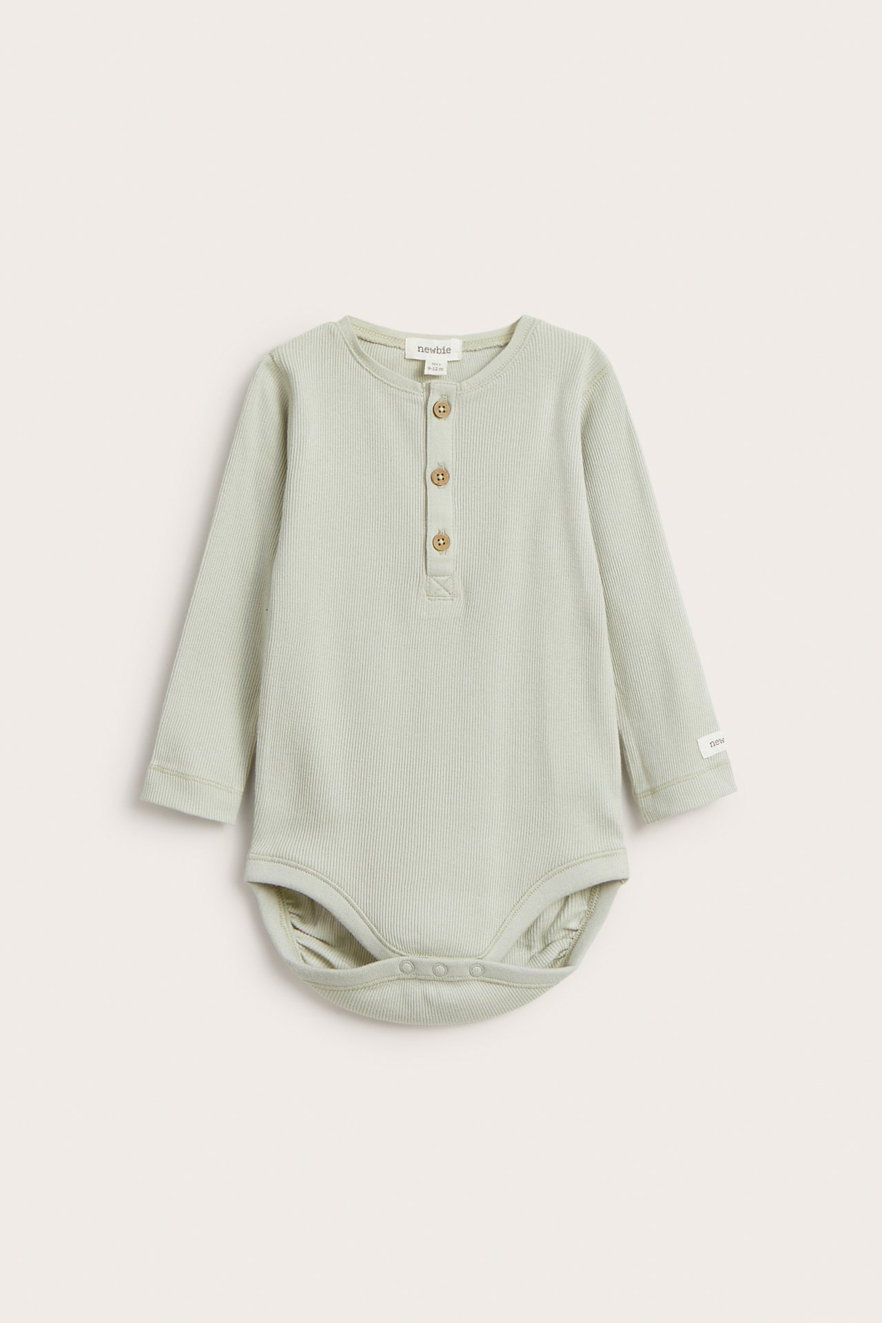 Vorderansicht: Hellgrüner gerippter Baumwoll-Babybody mit langen Ärmeln, Dreiknopfleiste und Druckknöpfen.
