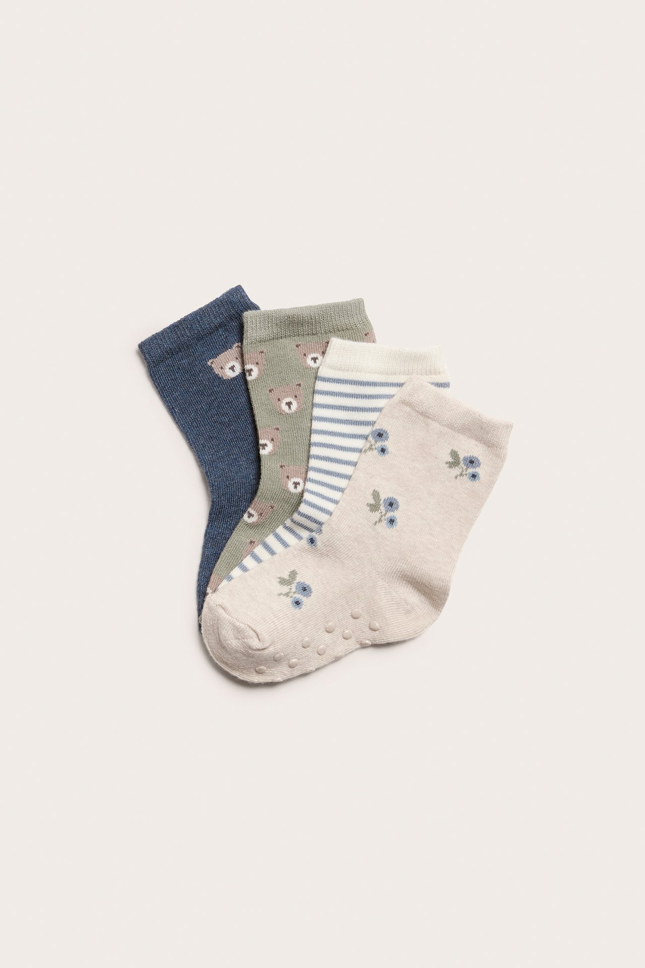 Top view of four kid's cotton socks: blue bear, green bear, striped, and beige floral, with anti-slip.