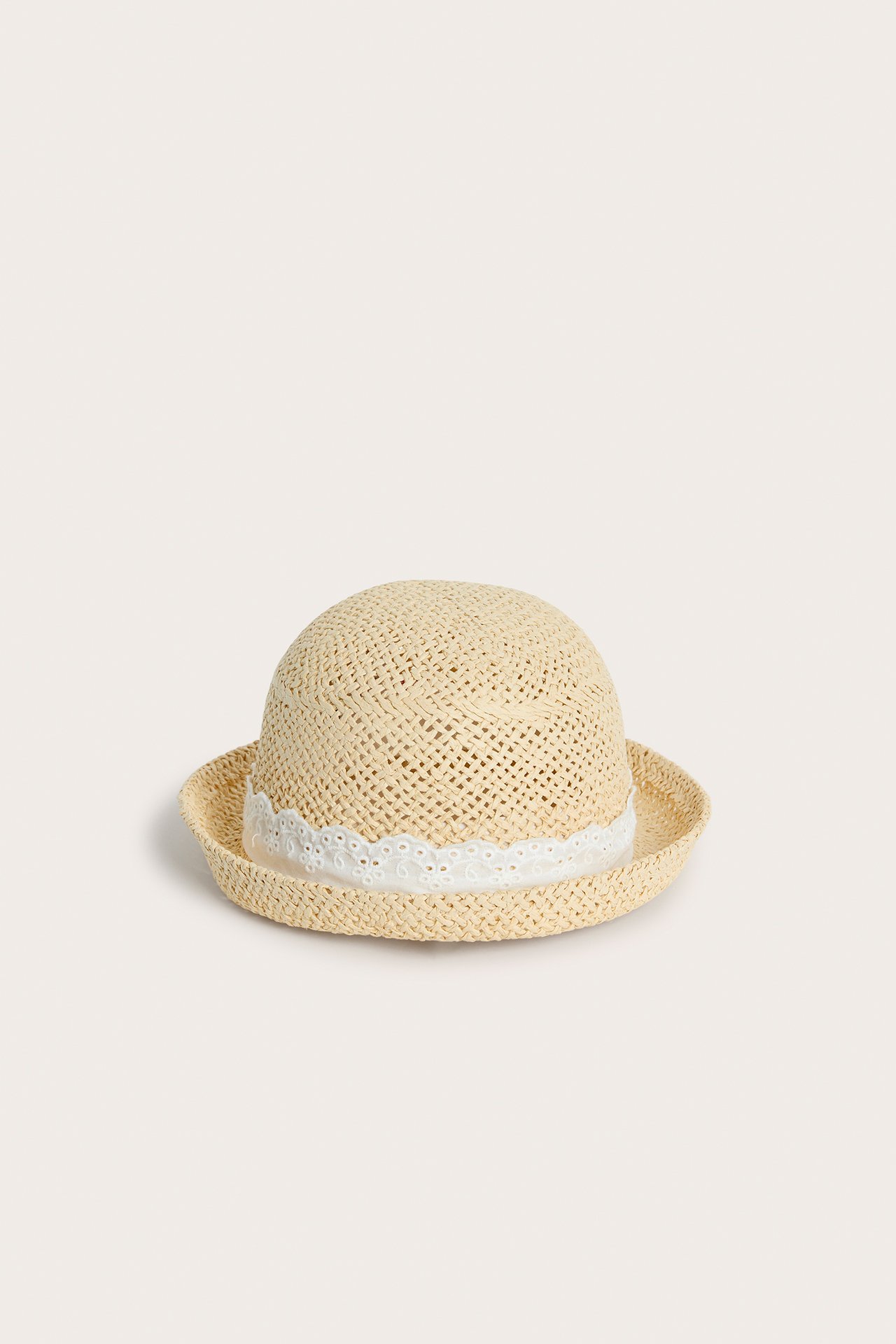 Front view of a light beige straw hat for kids with a white lace band around the crown.