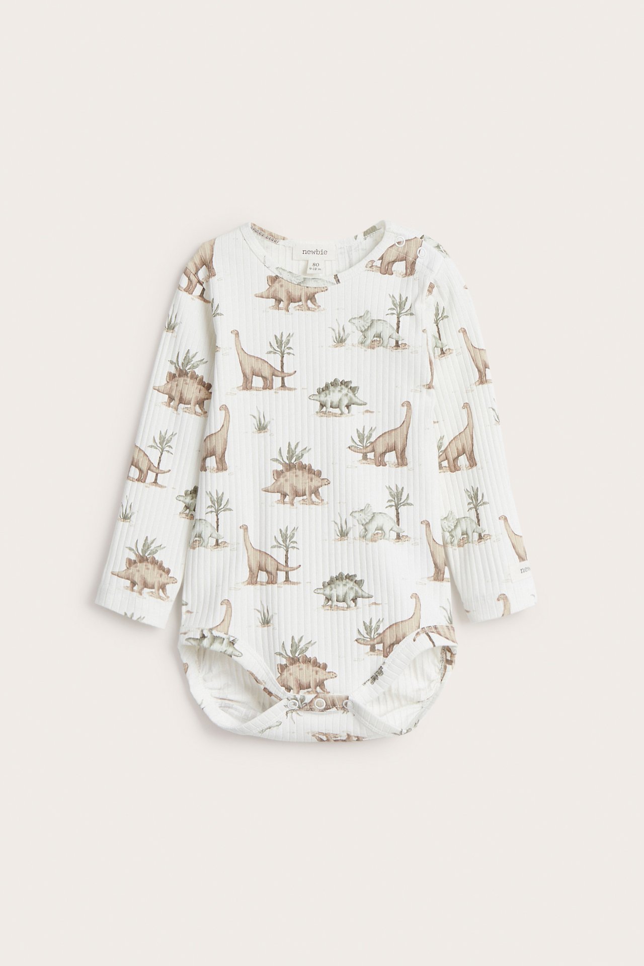 Front view of an off-white long-sleeved baby bodysuit with a dinosaur pattern and snap buttons.