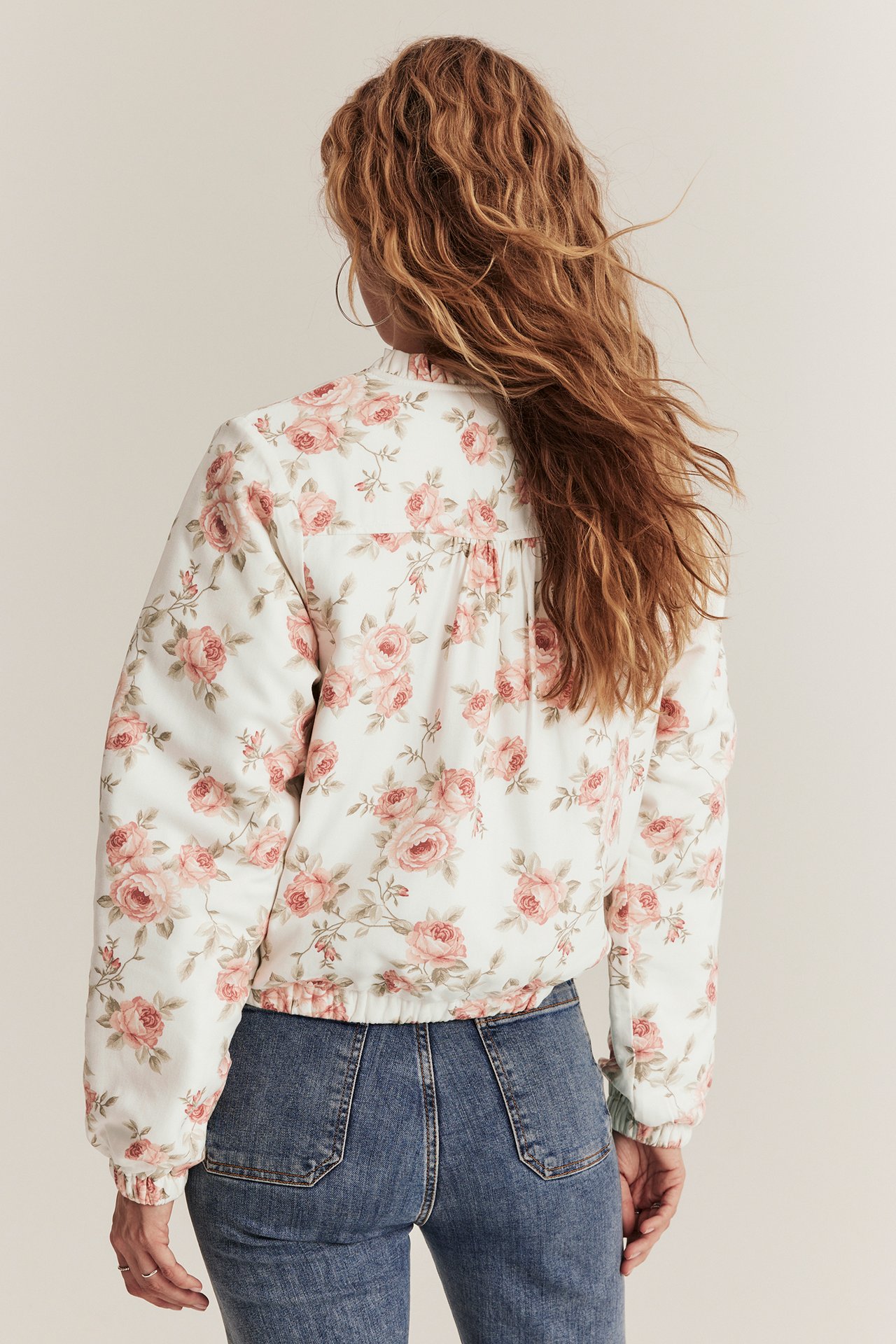 Printed bomber jacket in offwhite with small ruffle collar, zipper, and two front pockets.