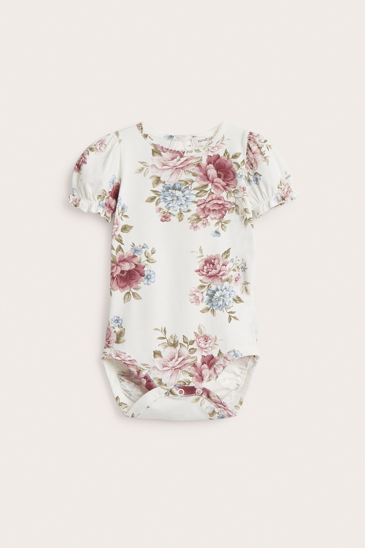 Front view of an off-white baby bodysuit with short puff sleeves, floral pattern, and snap buttons.