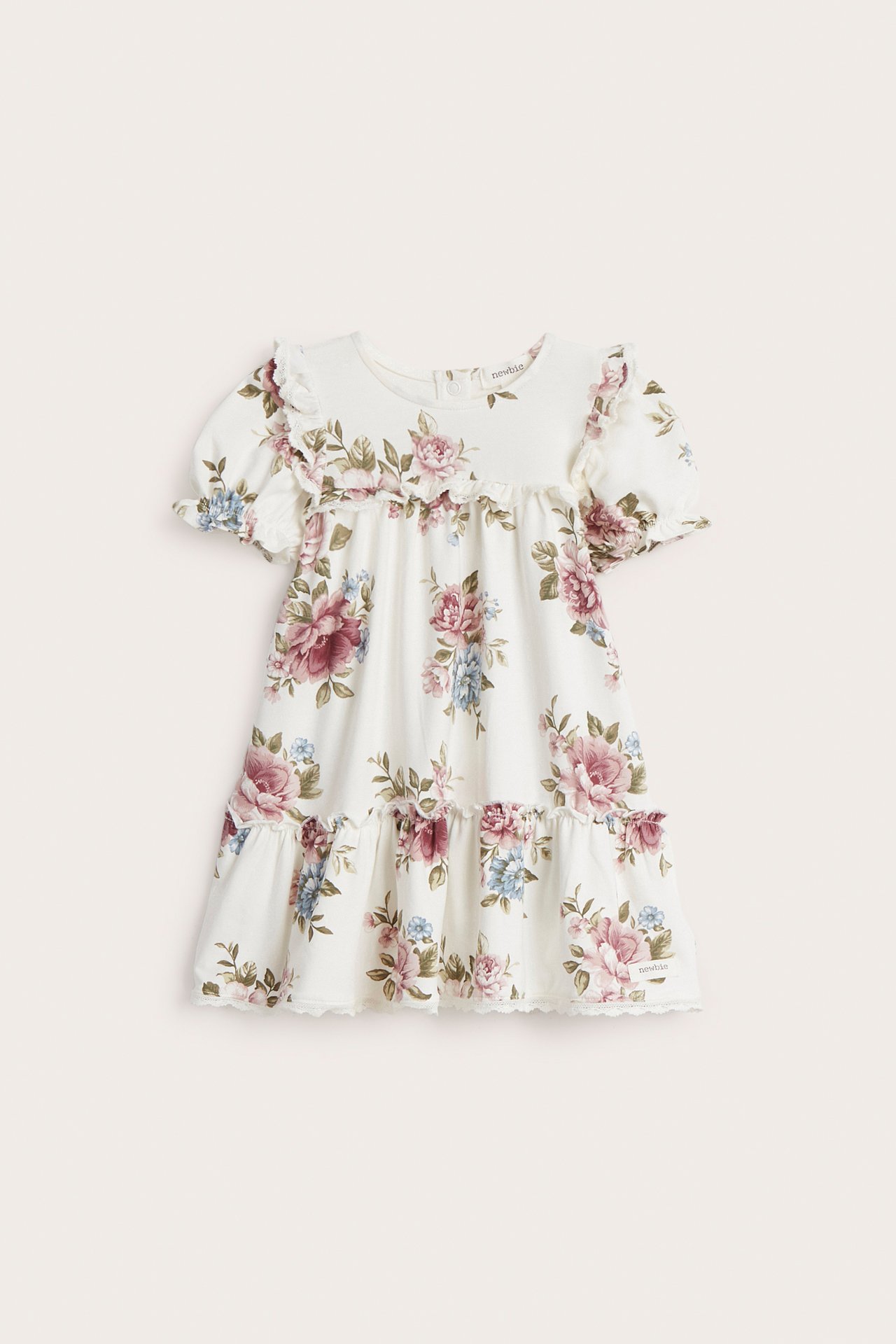 Front view of an off-white kid's floral jersey dress with puff sleeves, ruffles, and lace trim.